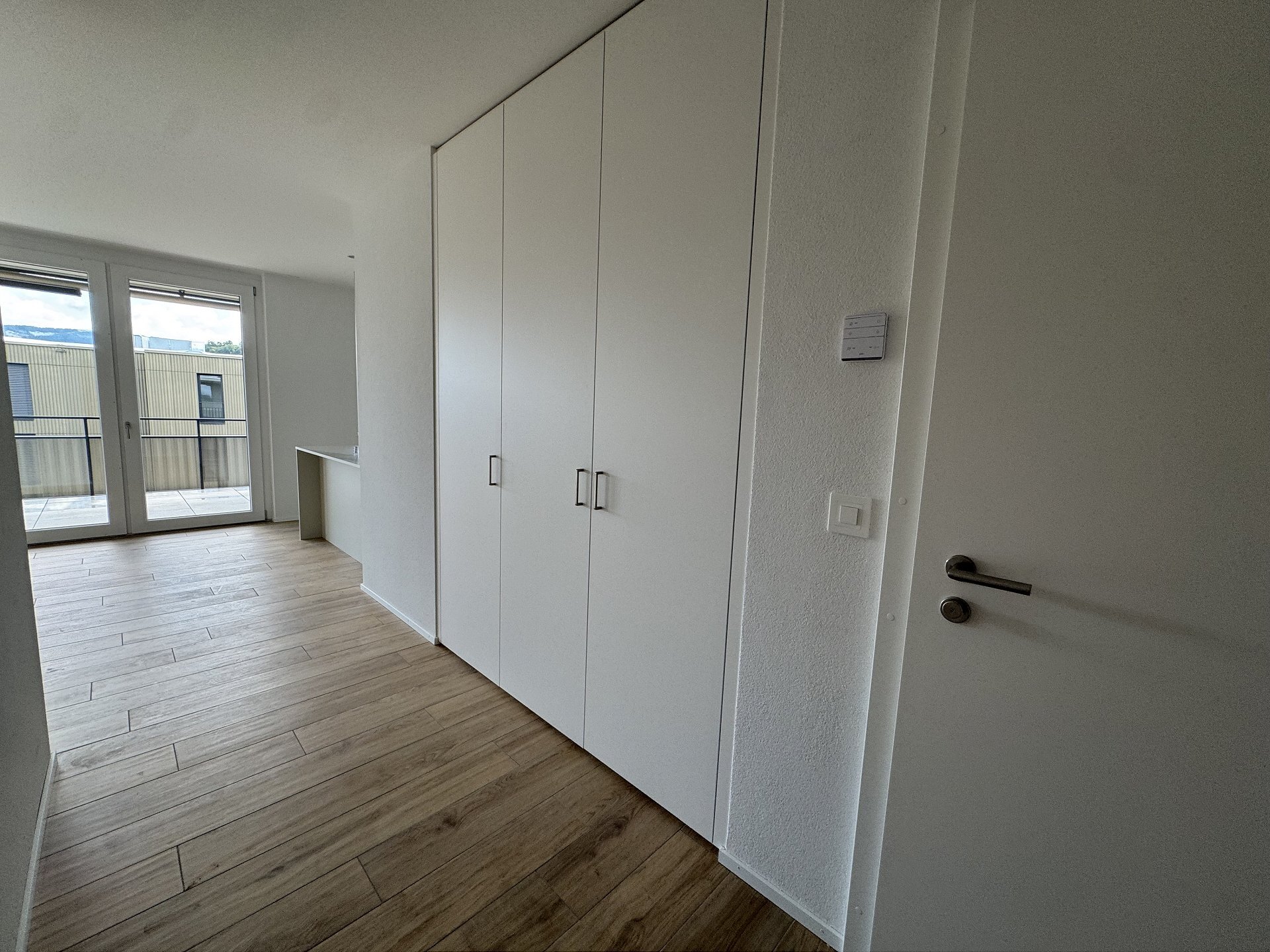 Heller Flur mit Balkonzugang und Einbauschrank