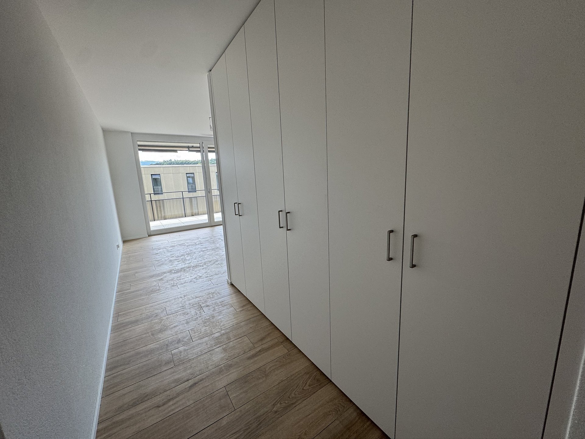 Heller Flur mit Einbauschrank und Balkonblick