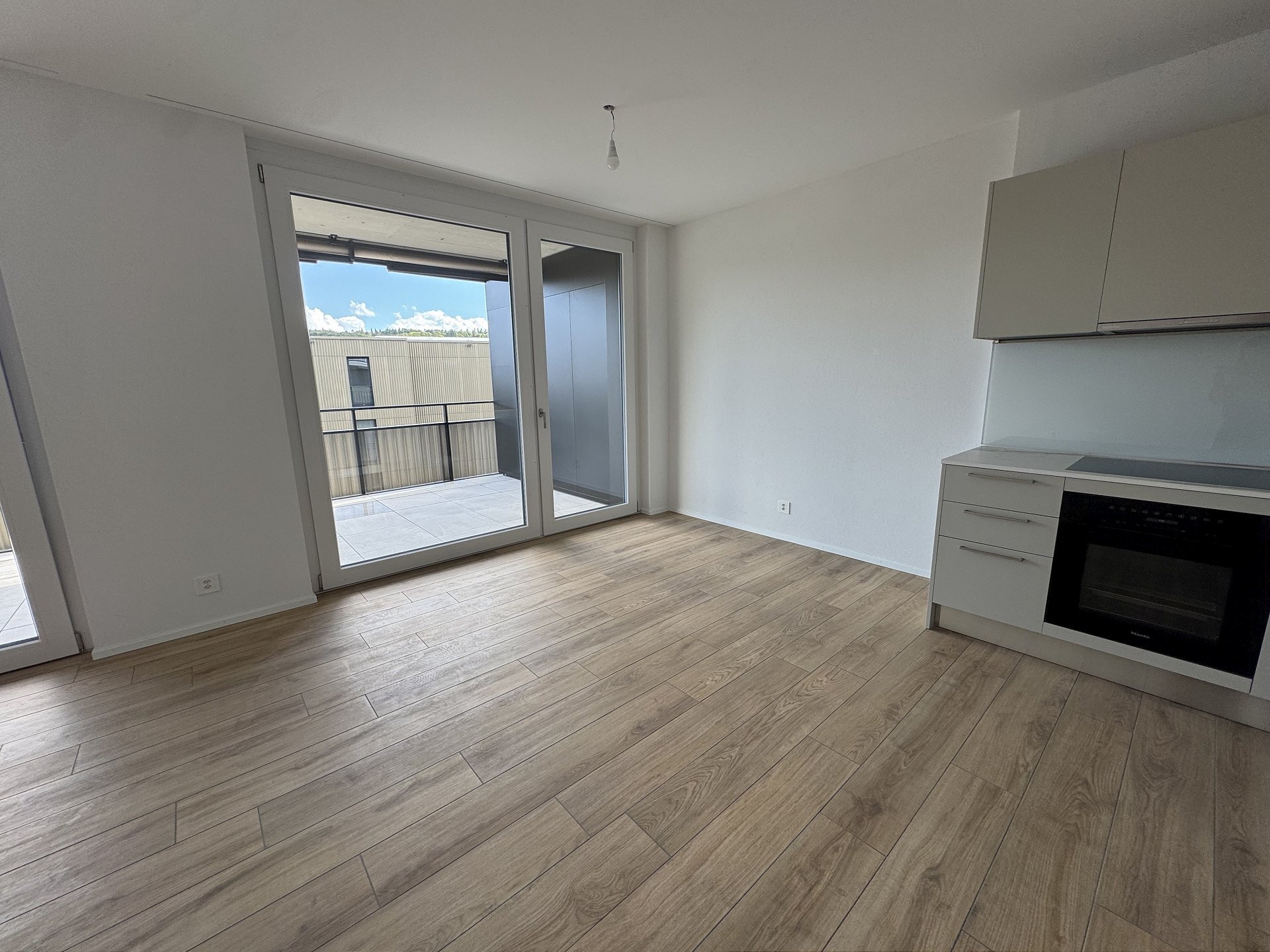 Heller Wohnraum mit Küchenzeile und Balkon