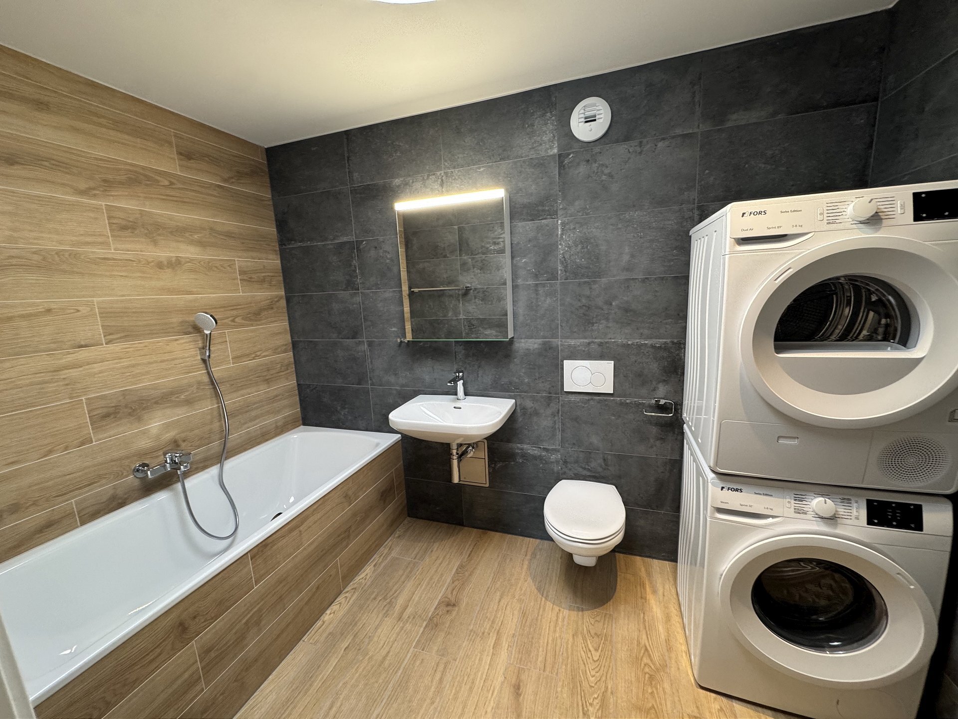 Modernes Badezimmer mit Badewanne und Waschtrockner