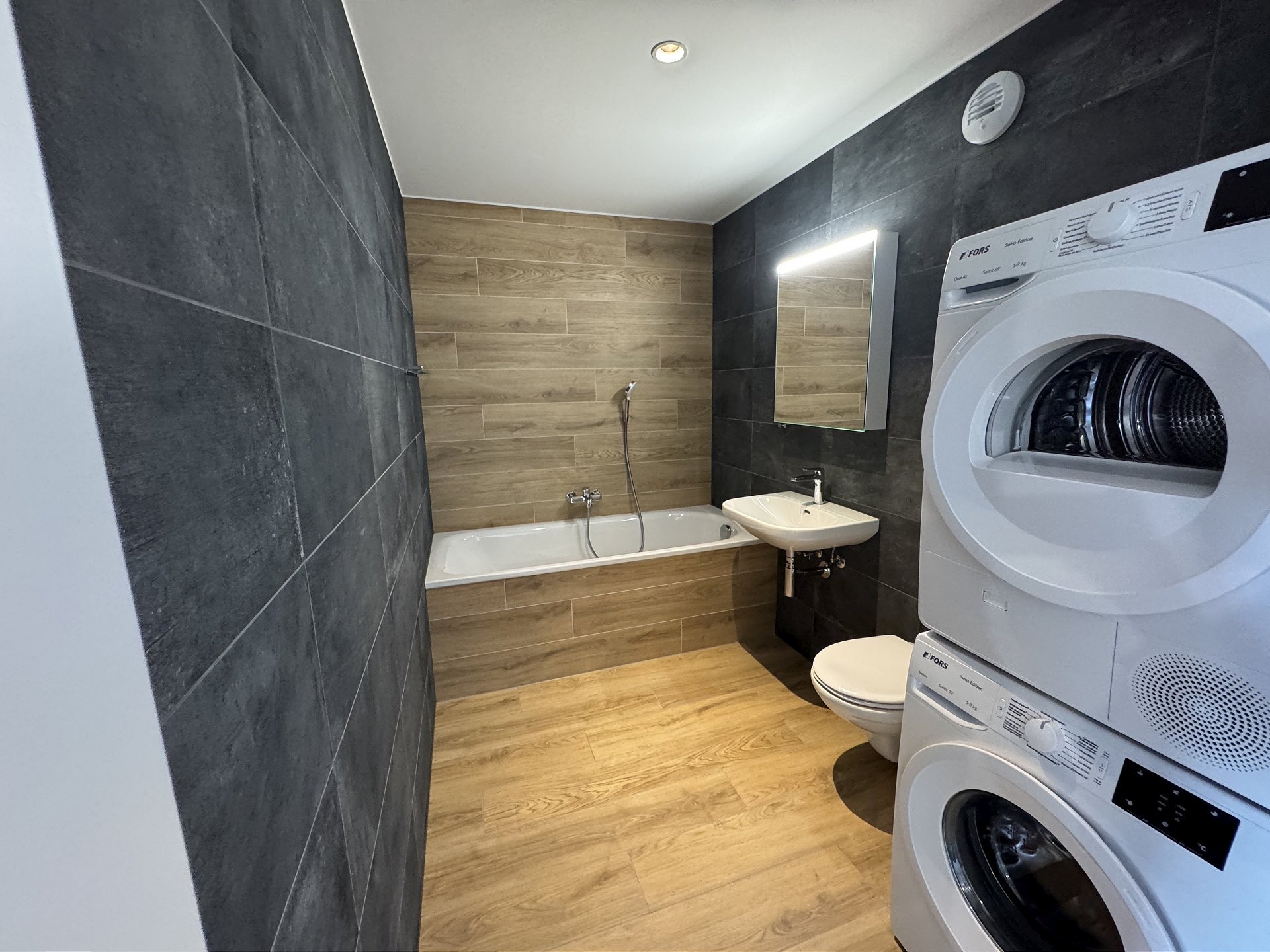 Modernes Badezimmer mit Badewanne und Waschturm