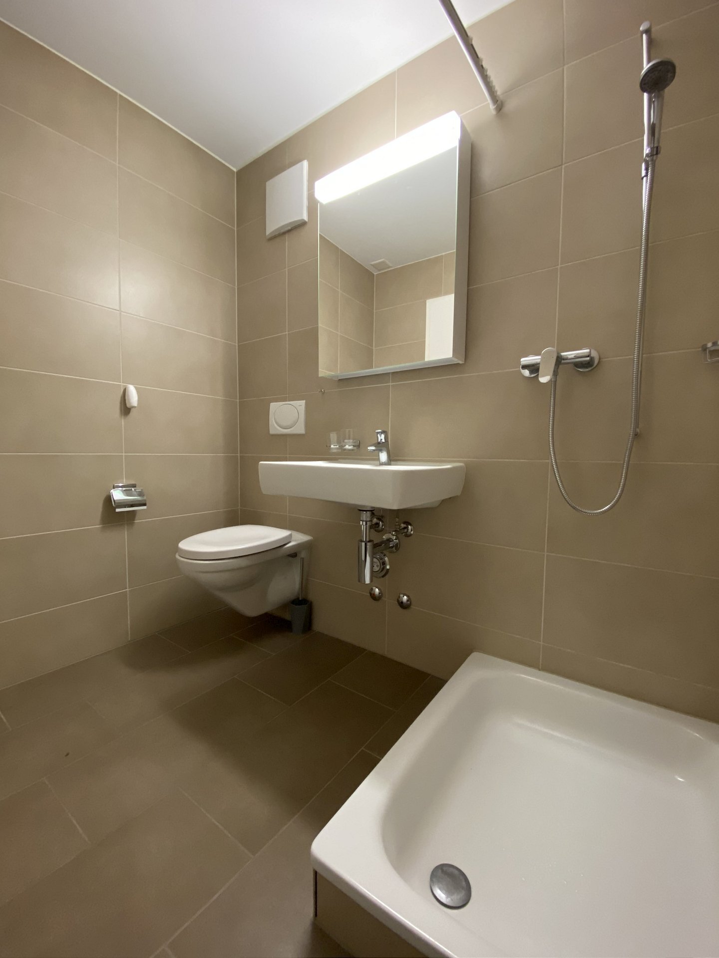 Badezimmer mit Wand-WC und Badewanne