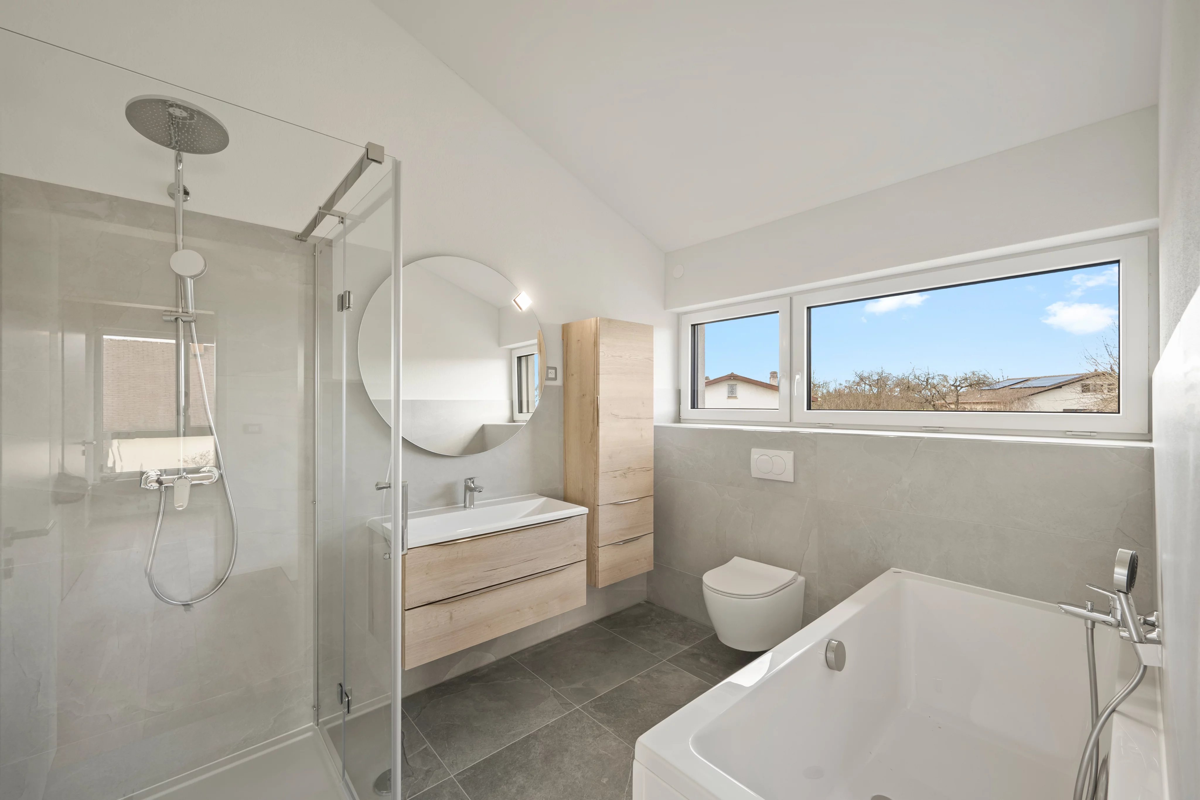 Modernes Badezimmer mit Dusche, Badewanne und Fensterblick