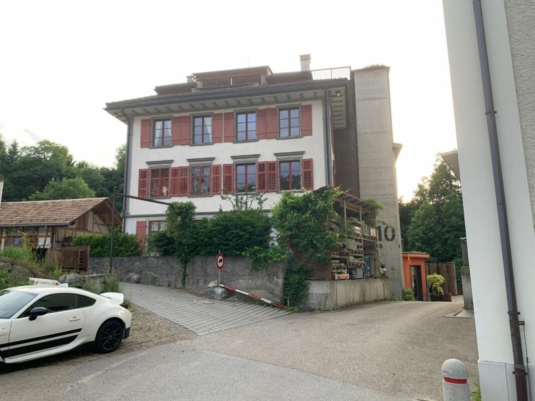 Außenansicht eines mehrstöckigen Hauses mit roten Fensterläden