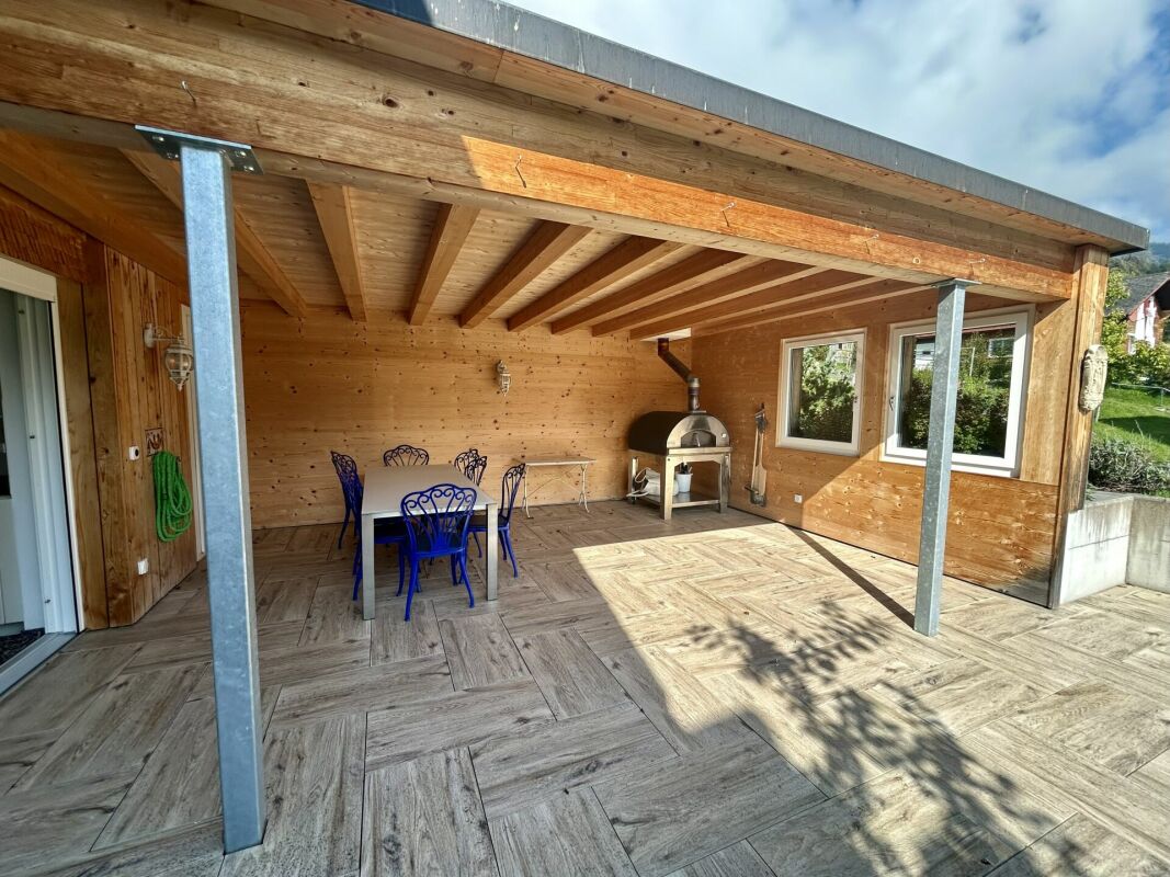 Überdachte Holzterrasse mit Grill