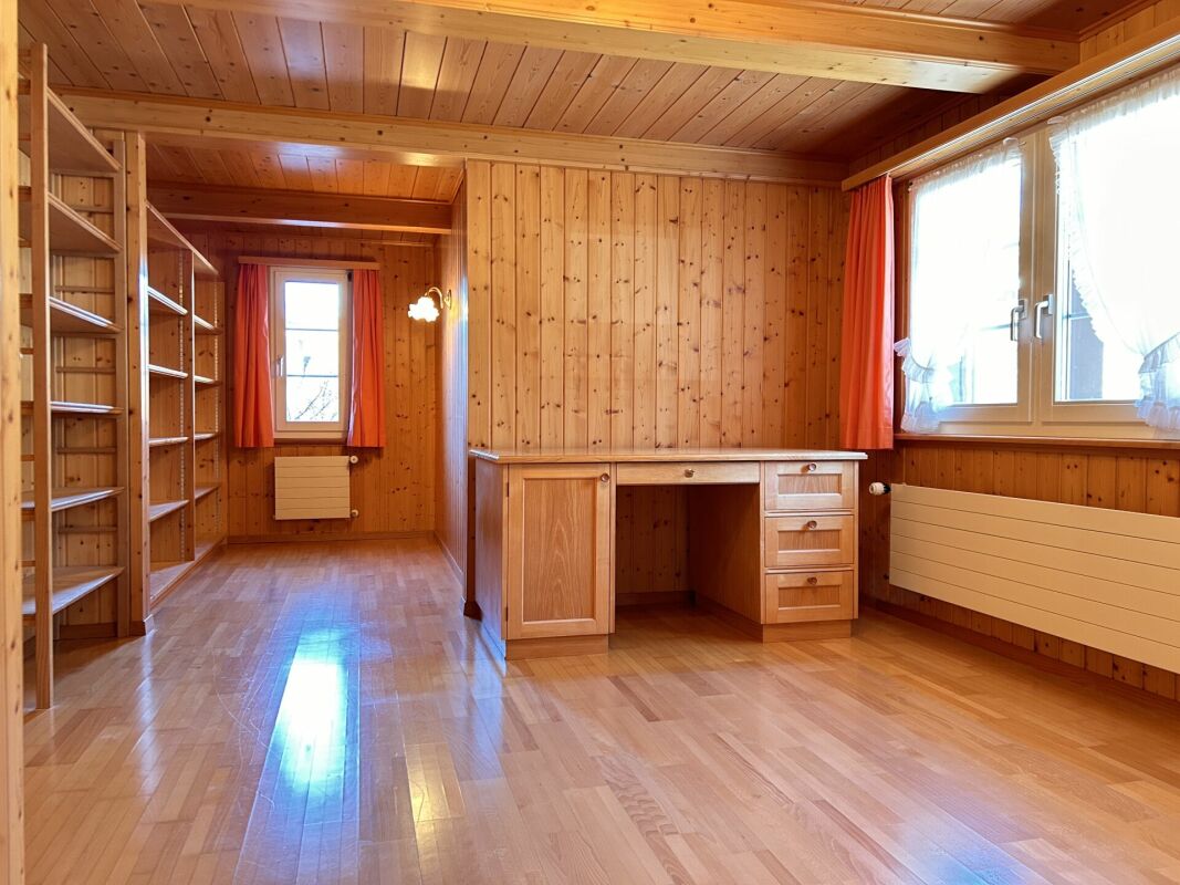 Holzvertäfelter Raum mit eingebauten Regalen und Schreibtisch