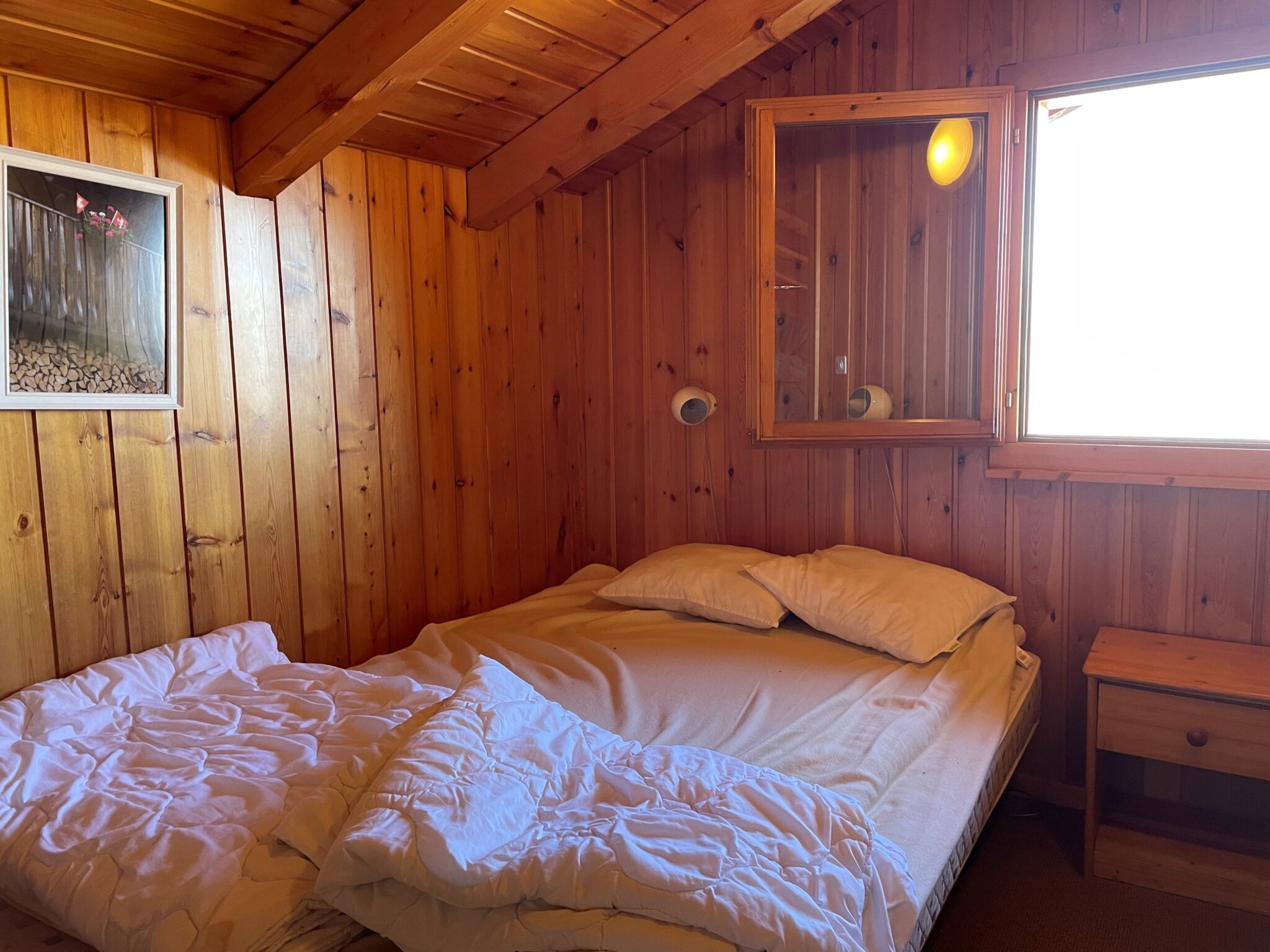 Kleines, rustikales Schlafzimmer mit Holzverkleidung