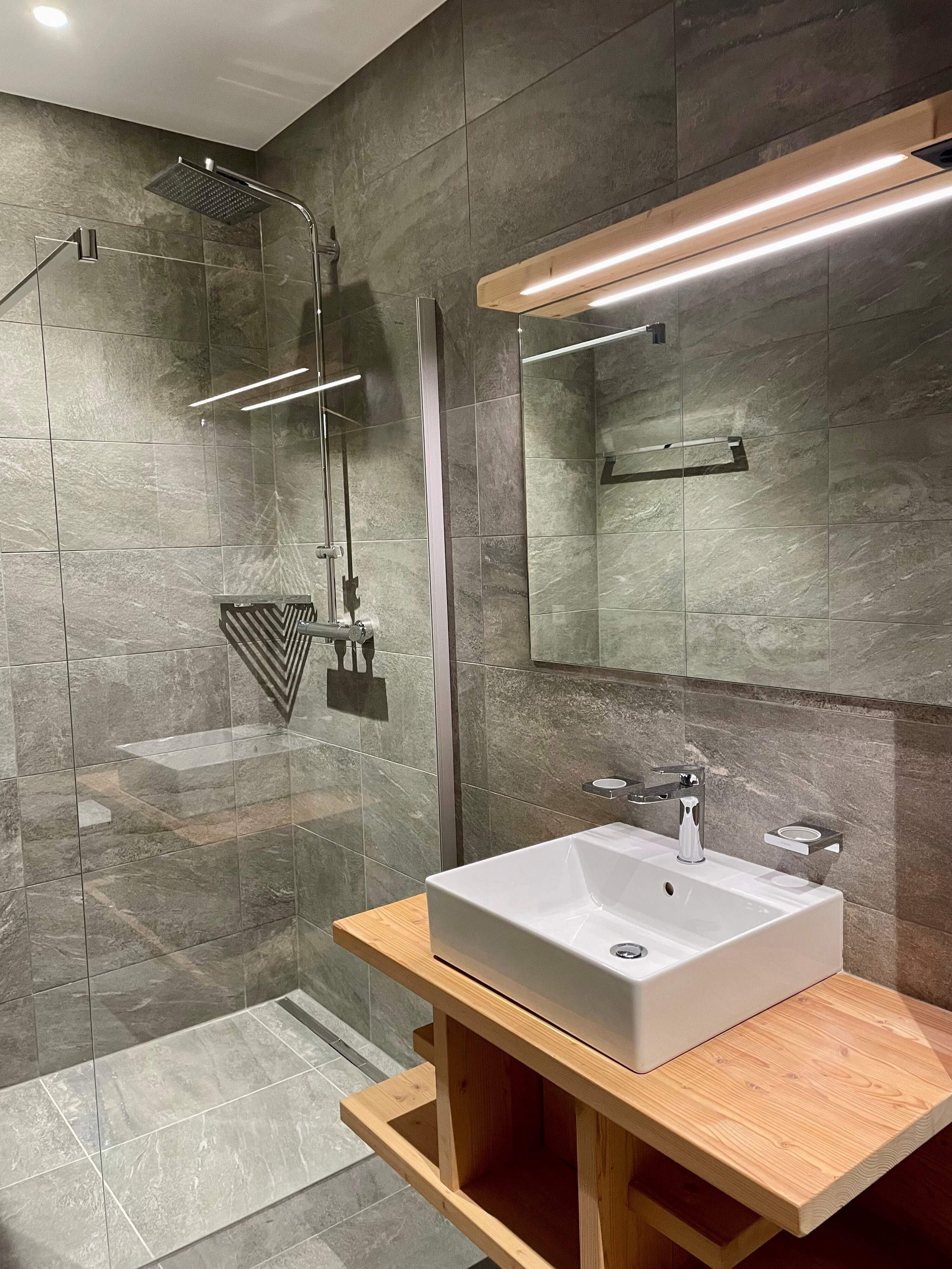 Modernes Badezimmer mit Walk-in-Dusche und Holzwaschtisch