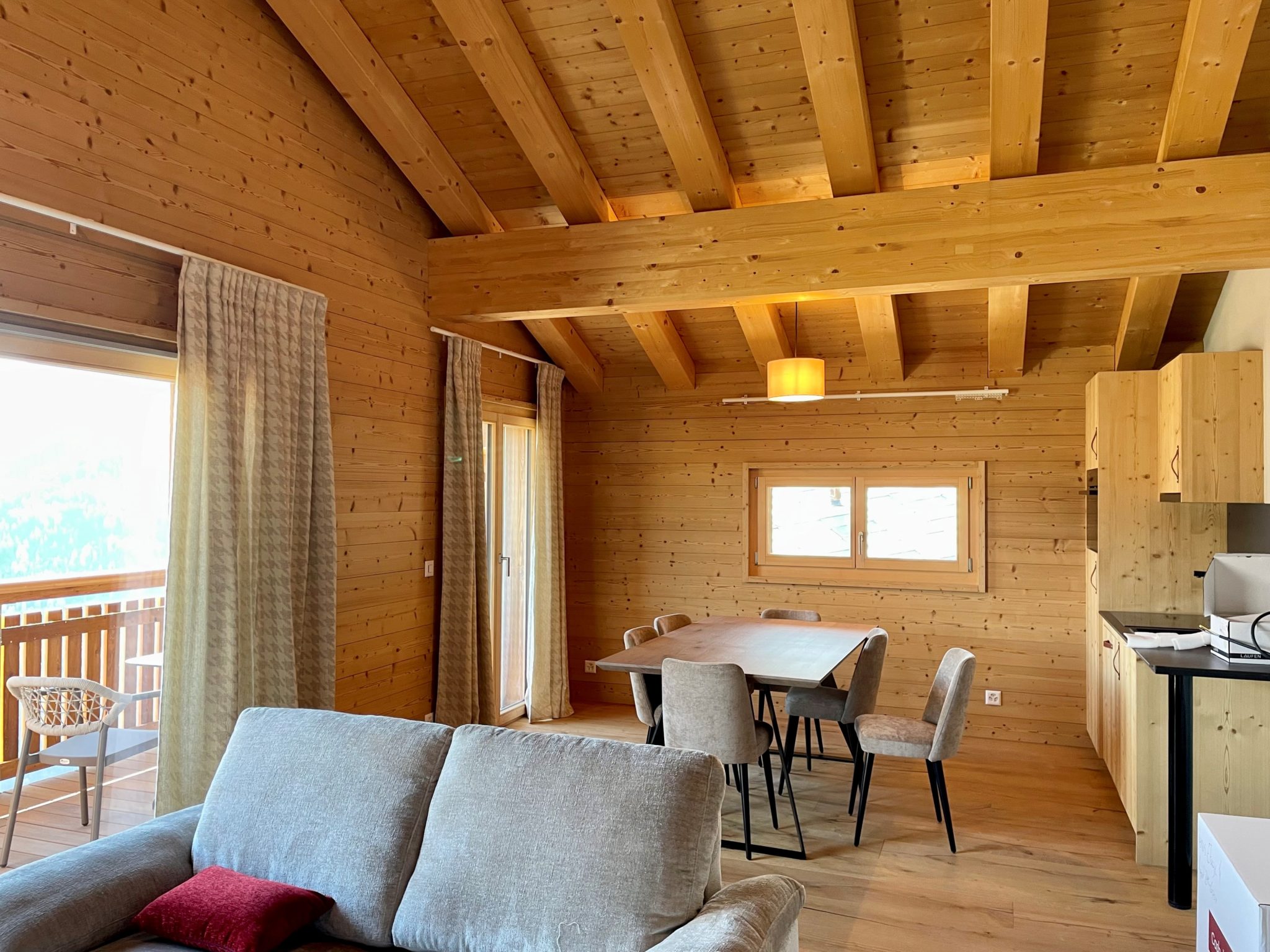 Holzvertäuhtes Wohn- und Esszimmer mit offener Küche