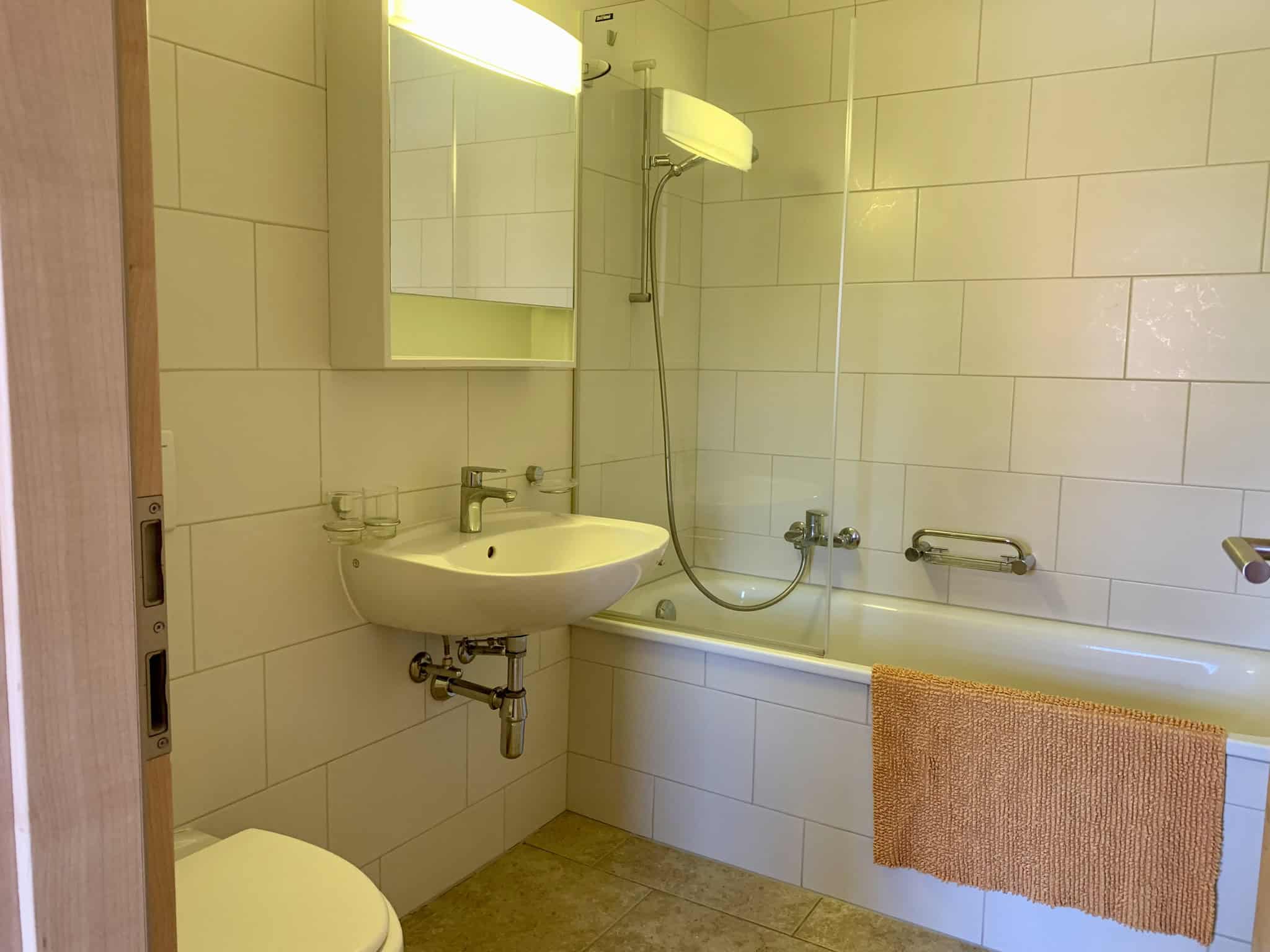 Badezimmer mit Wanne und Waschtisch