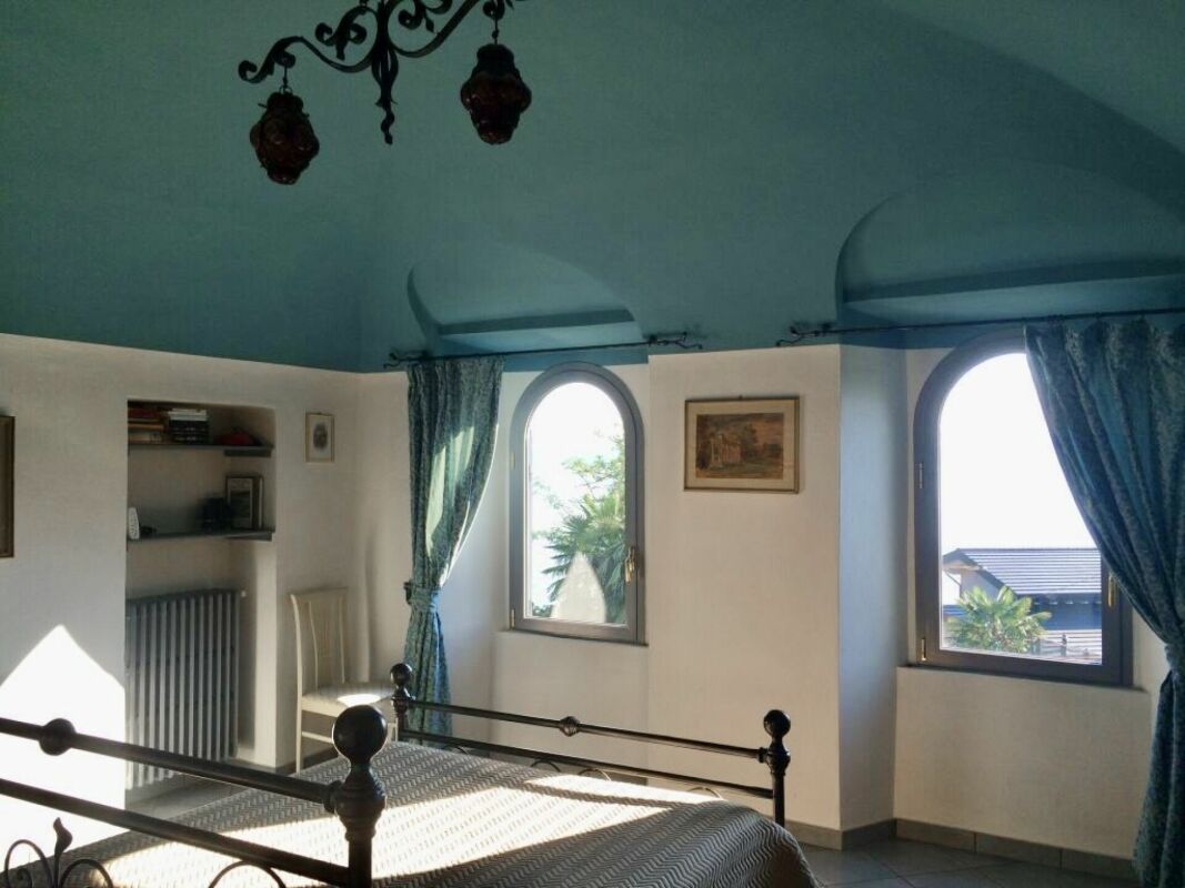 Schlafzimmer mit hohen Decken und Rundbogenfenstern