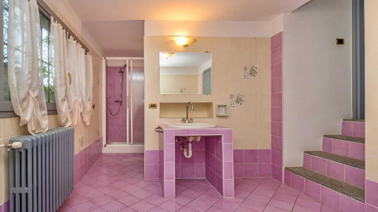 Badezimmer mit rosa Fliesen und Fenster
