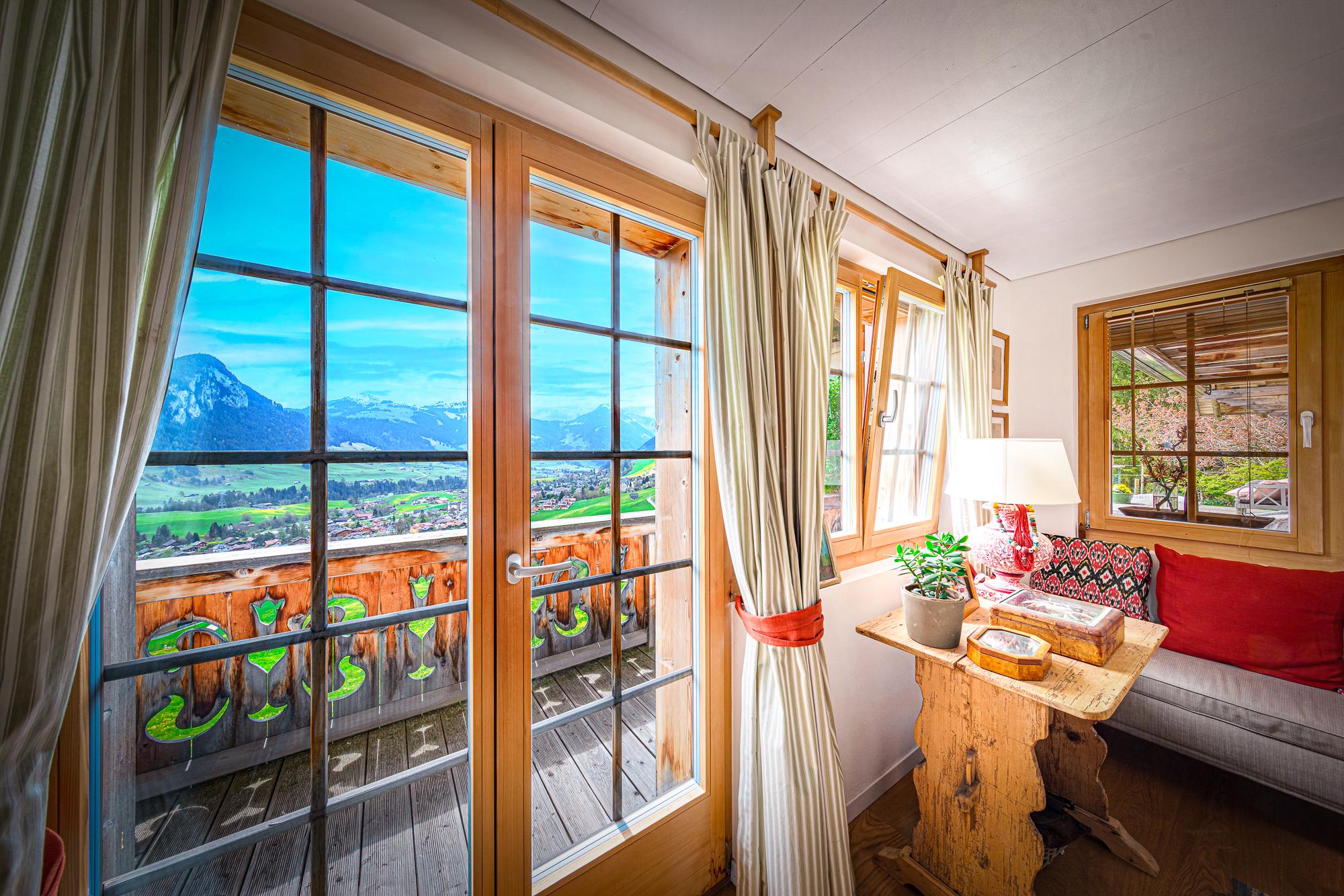 Gemütlicher Blick in einen alpinen Wohnraum mit Balkon und Bergpanorama