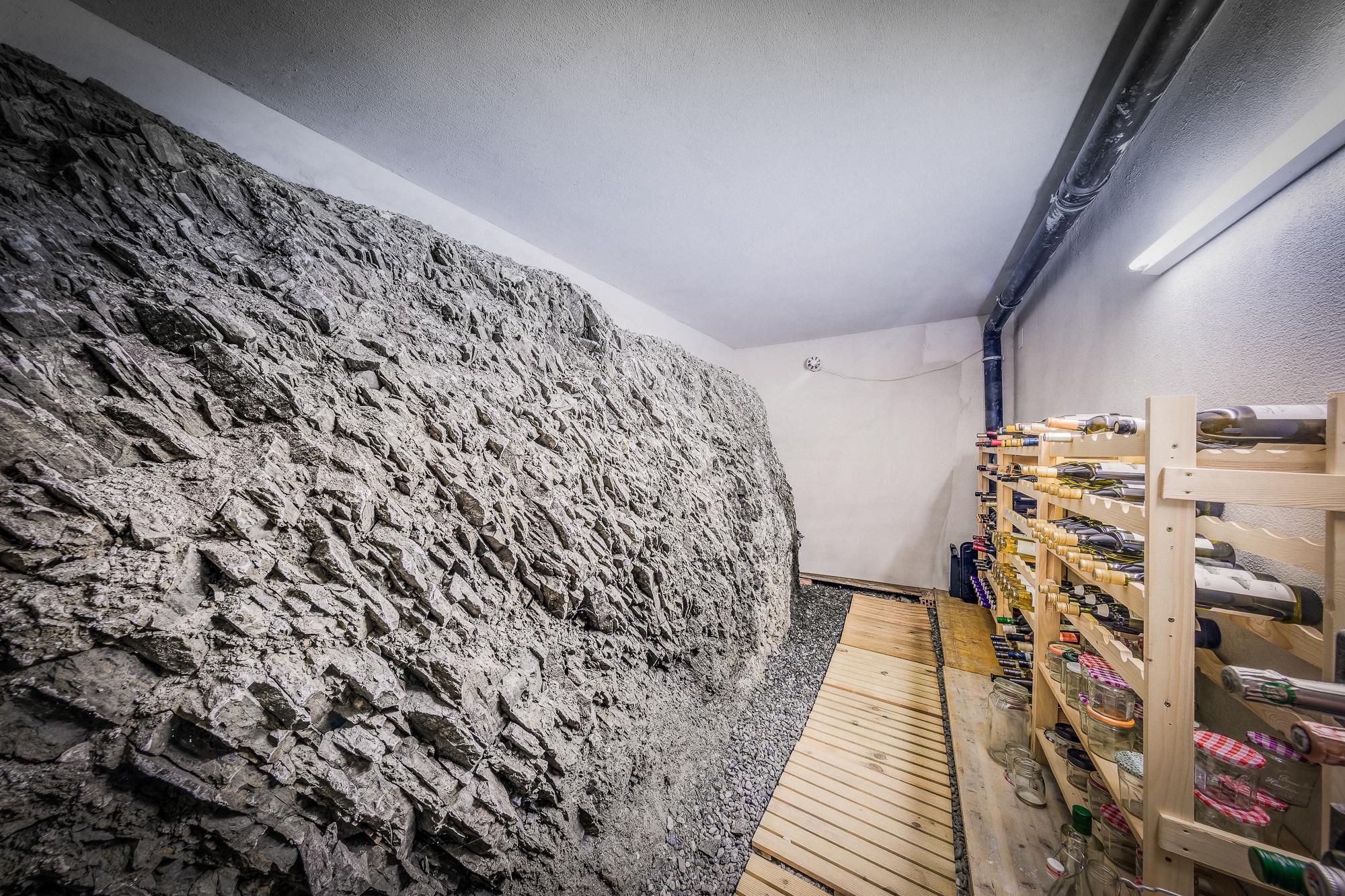 Weinkeller mit Natursteinwand und Flaschenregalen