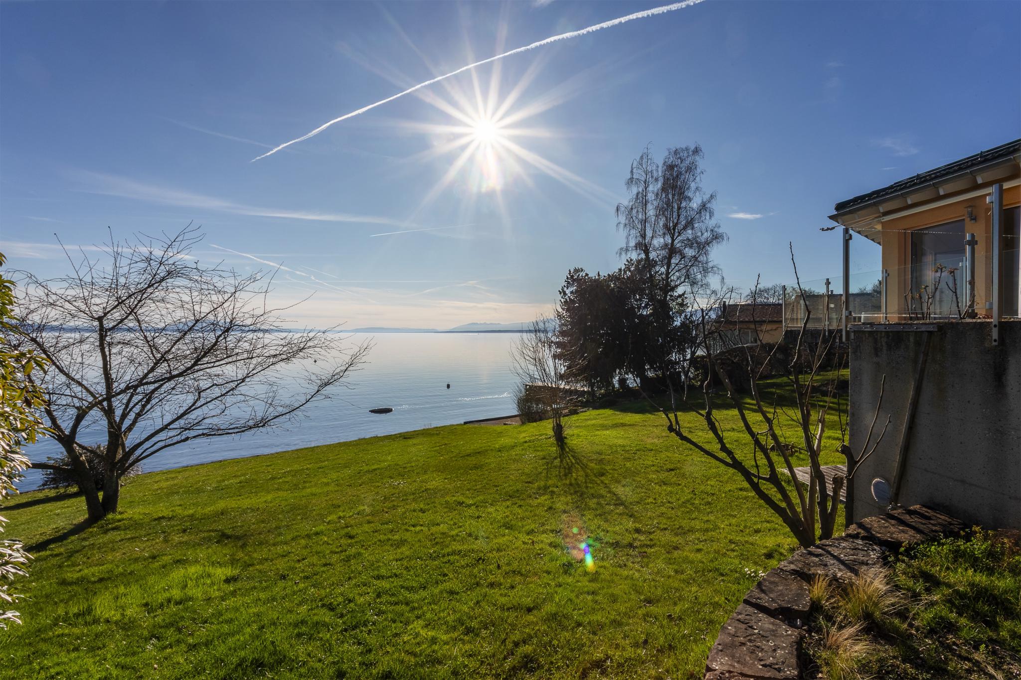 Seeblick mit sonnigem Garten
