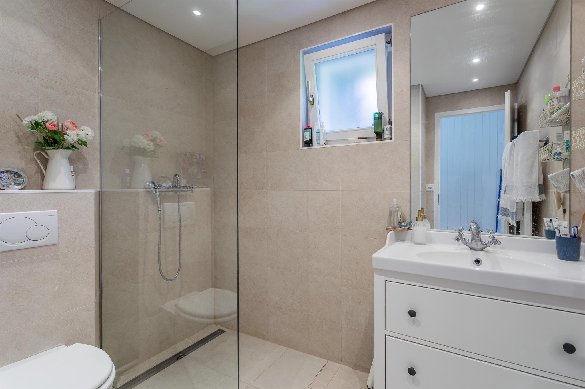Modernes Badezimmer mit Glasdusche und Waschtisch