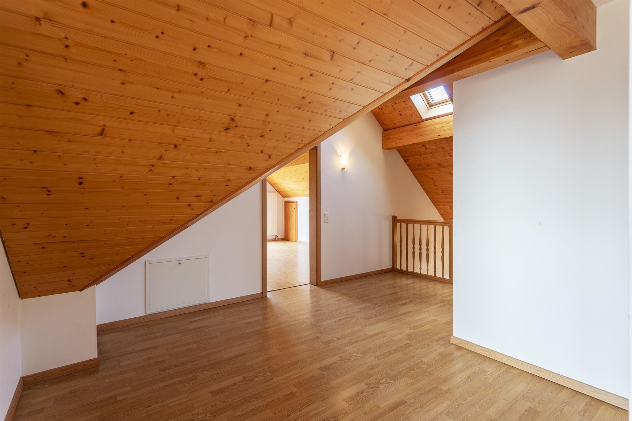 Dachgeschossraum mit Holzbalken und Holzdecke