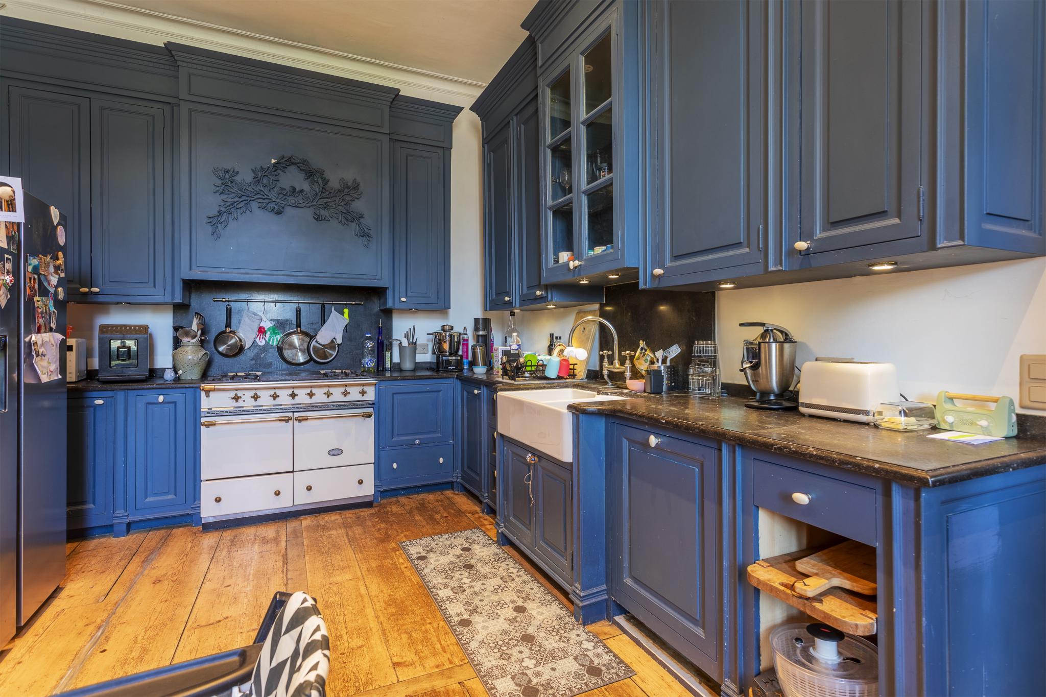 Dunkle Landhausküche mit blau lackierten Einbauten