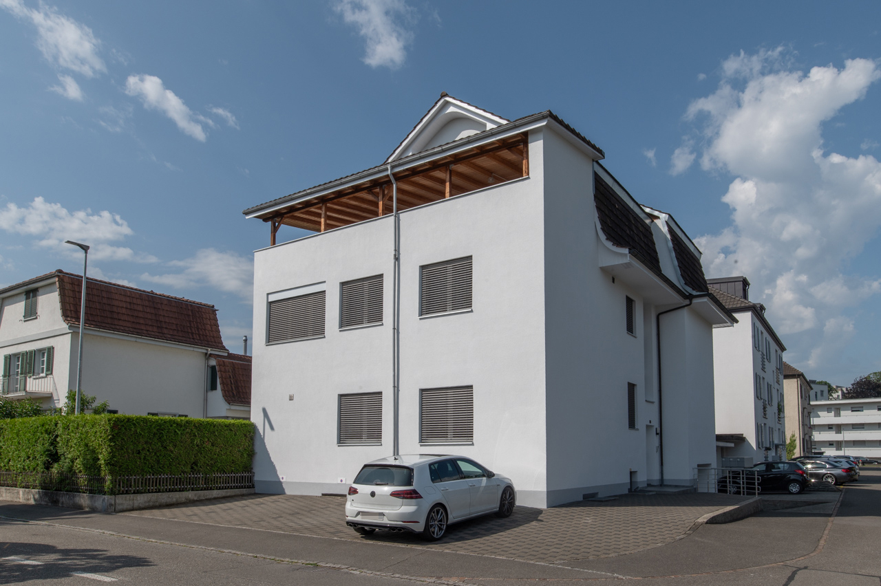 Wohnhaus mit weißer Fassade und Satteldach