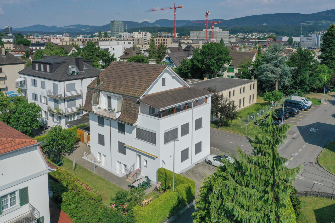 Städtische Wohnhäuser mit Blick auf Berge und Kräne
