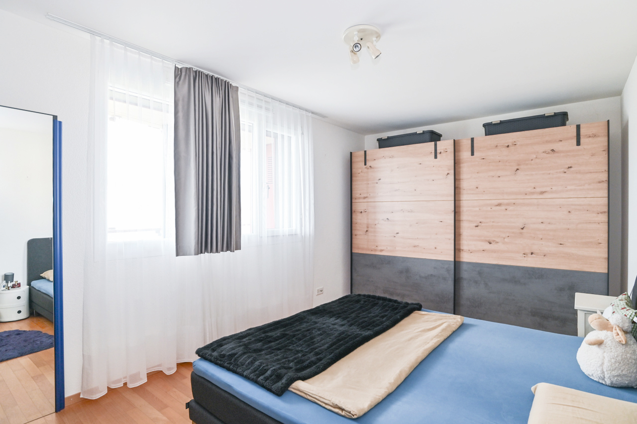 Schlafzimmer mit Fensterwand und großem Kleiderschrank