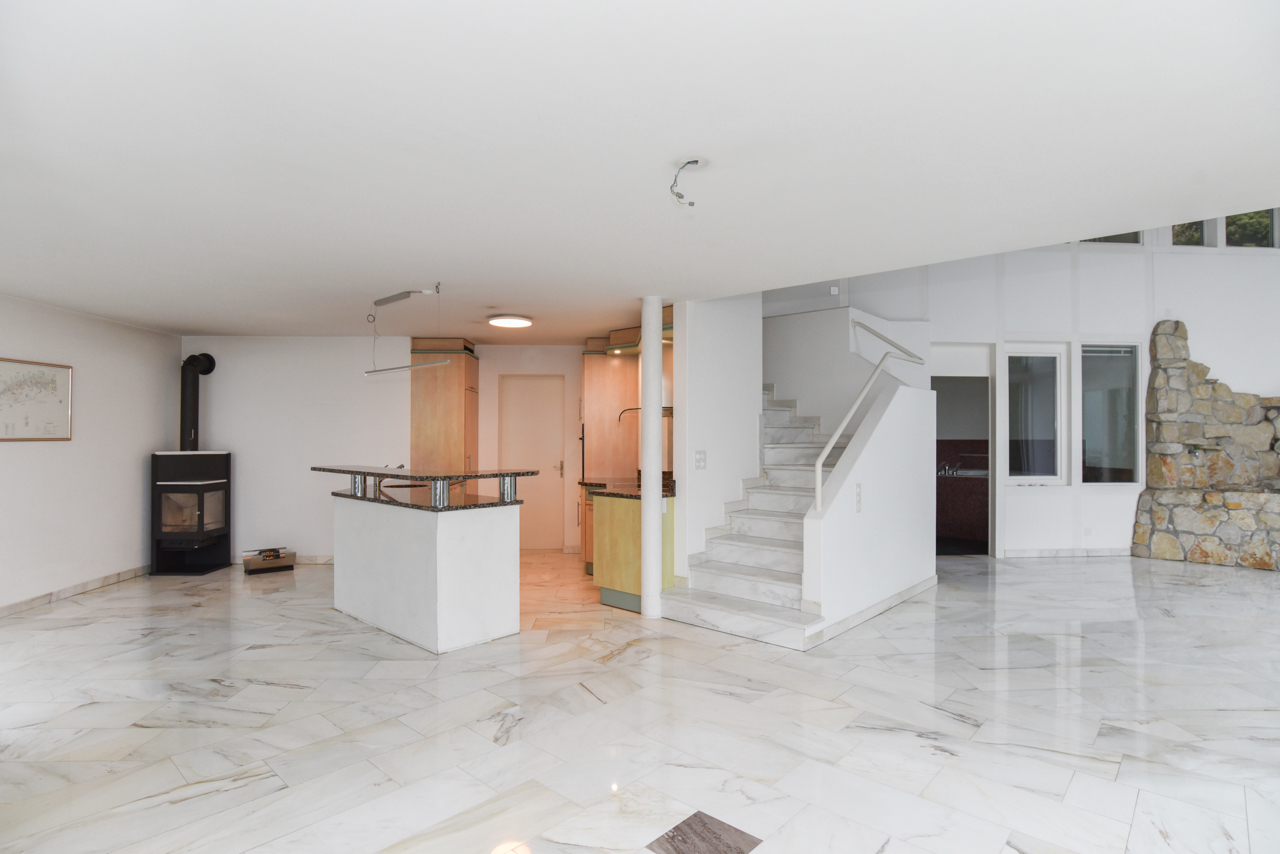 Offener Wohnbereich mit Kamin und Treppe