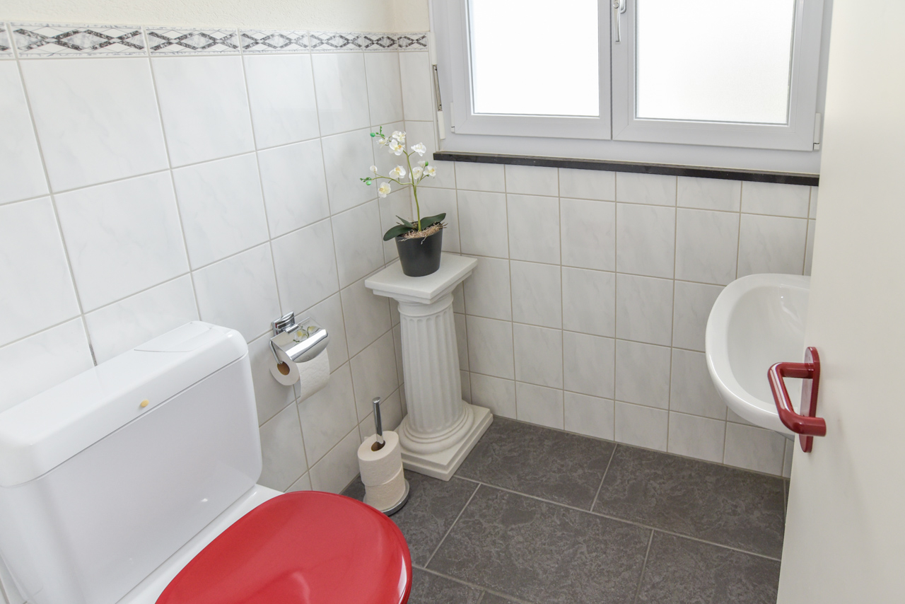 Gäste-WC mit hellem Fliesenbelag
