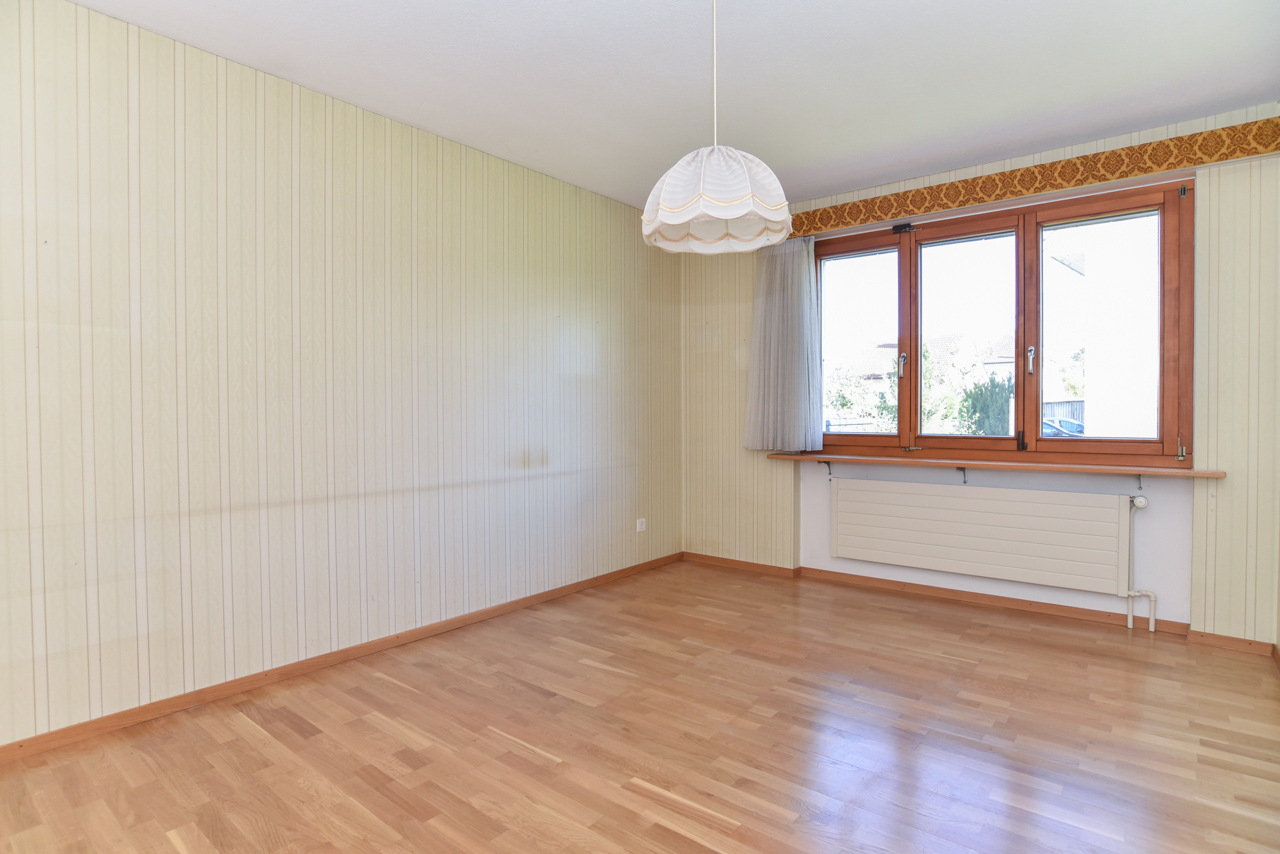 Leerer Wohnraum mit Fenster und Laminatboden