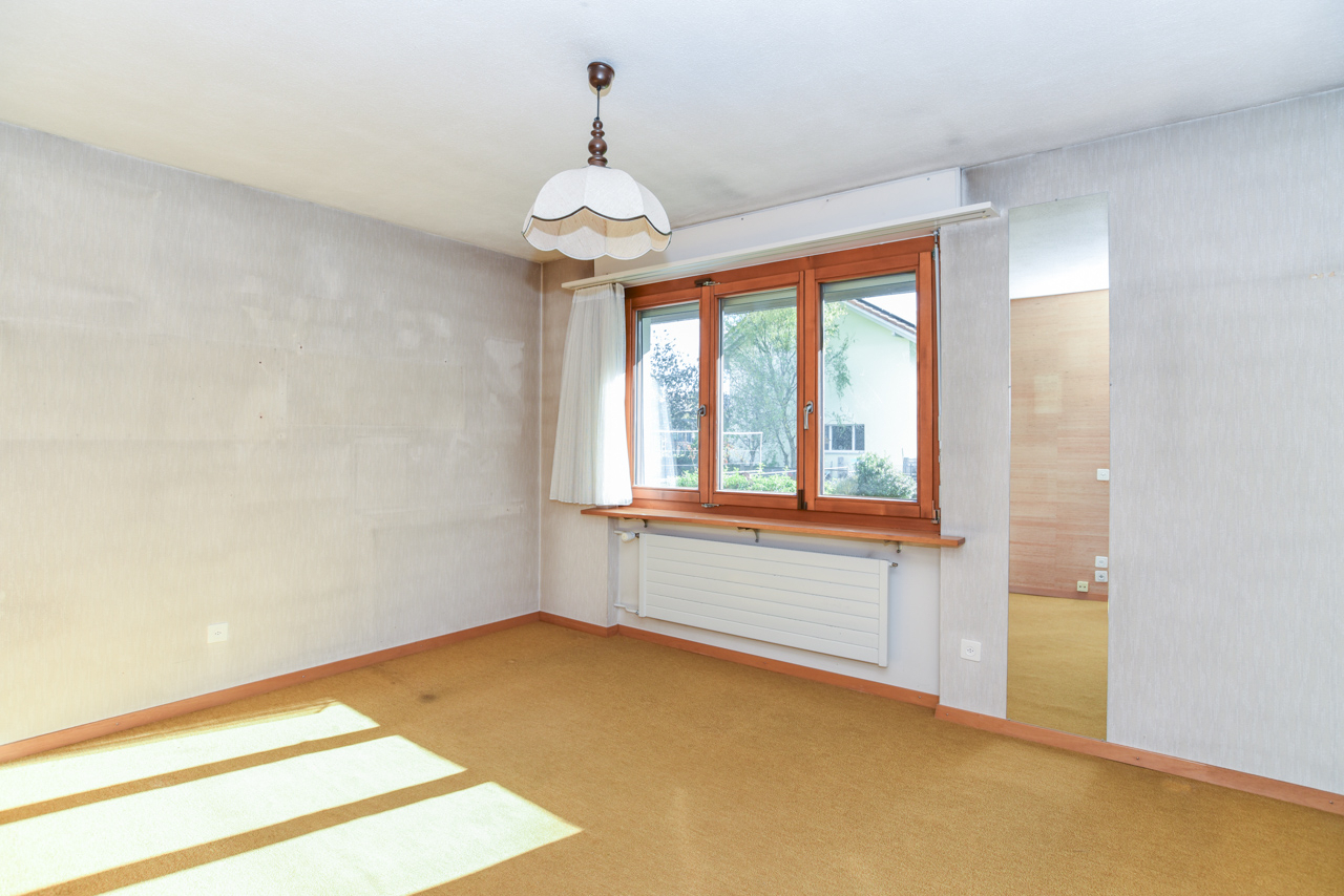 Leeres Zimmer mit Holzfenster und Teppichboden