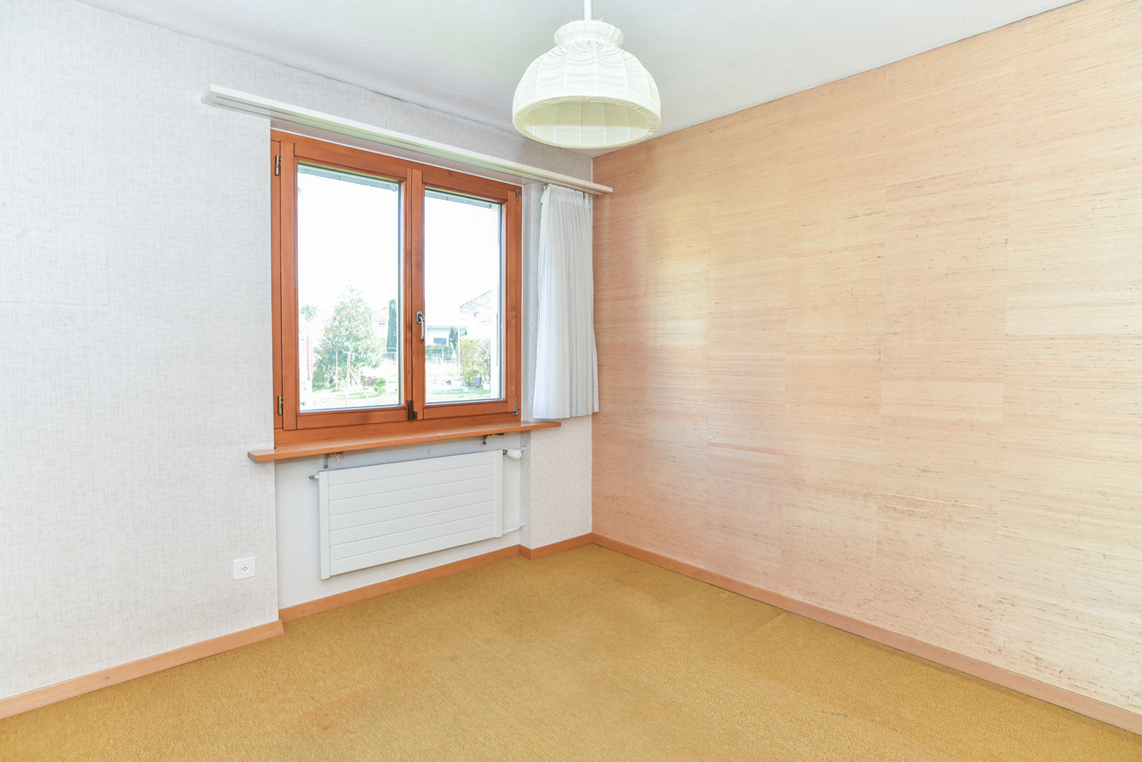 Leerer Raum mit Holzfenster und Heizkörper