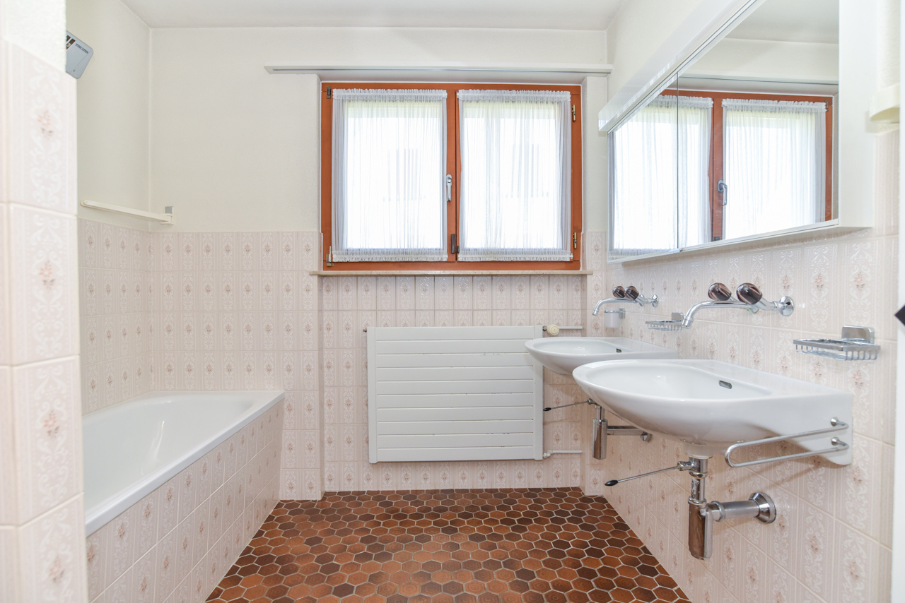 Badezimmer mit Badewanne und Doppelwaschbecken