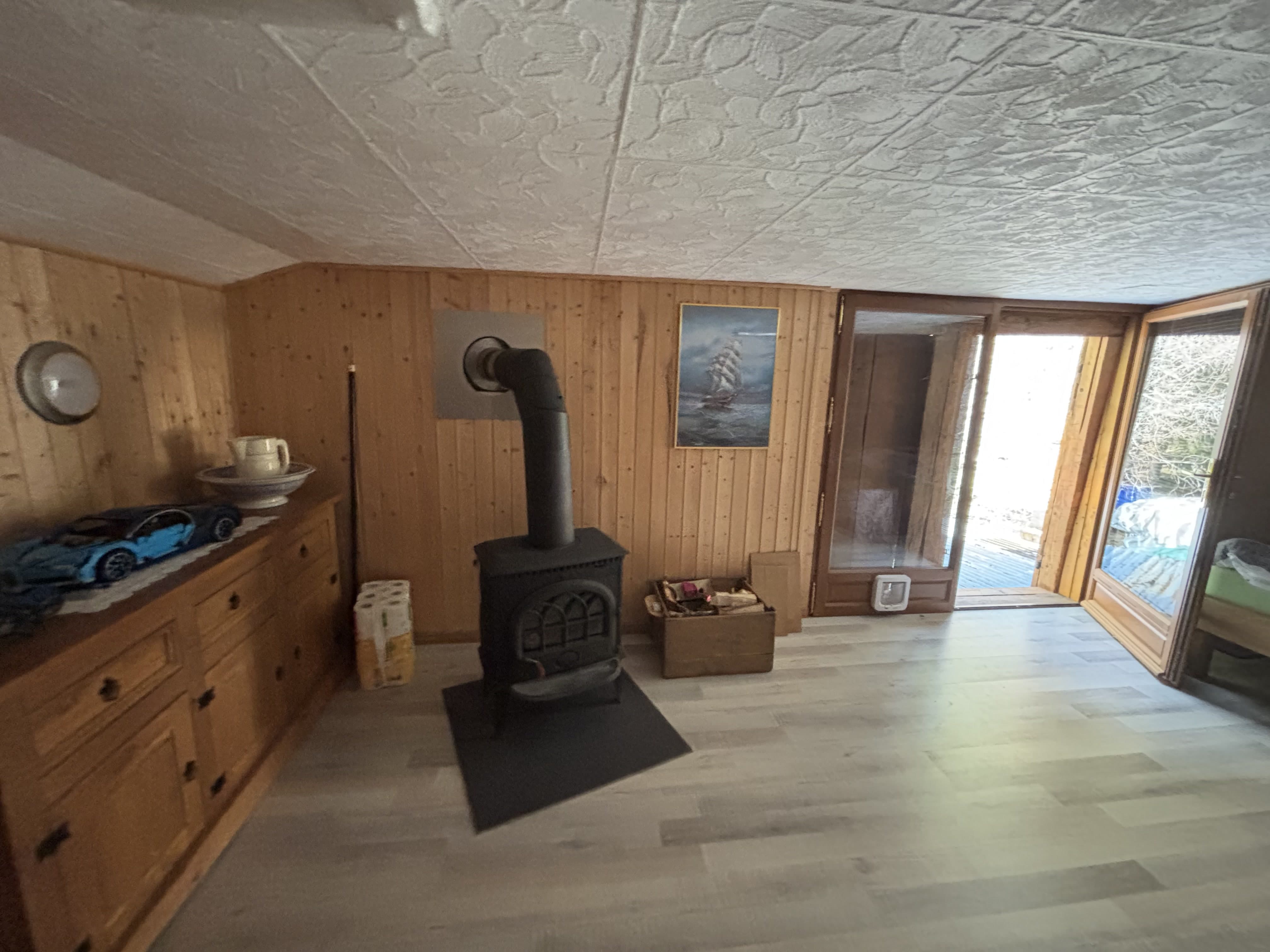 Wohnraum mit Holzverkleidung und Kaminofen