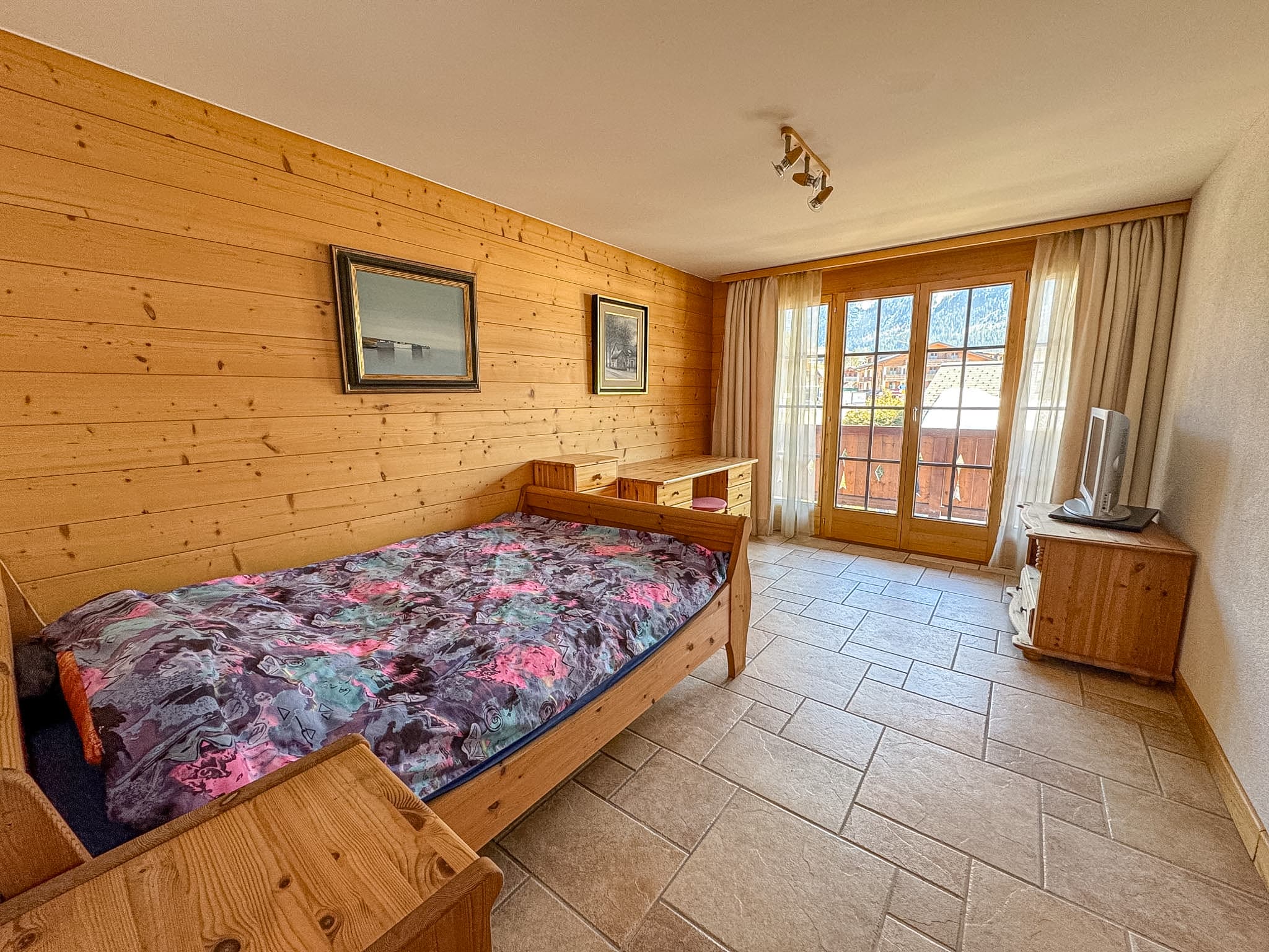 Gemütliches Schlafzimmer mit Holzverkleidung und Bergblick