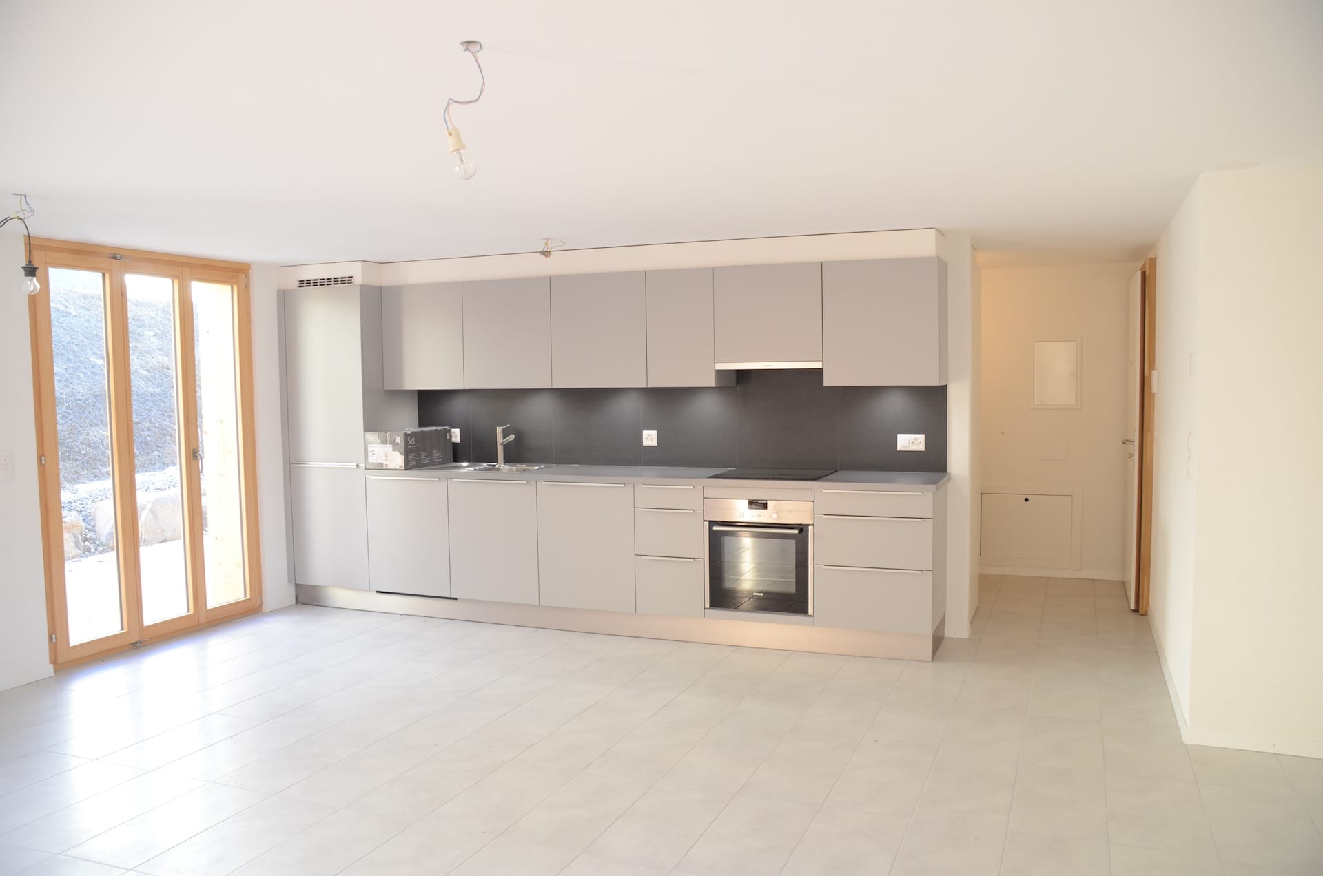 Offene moderne Küche mit großer Fensterfront