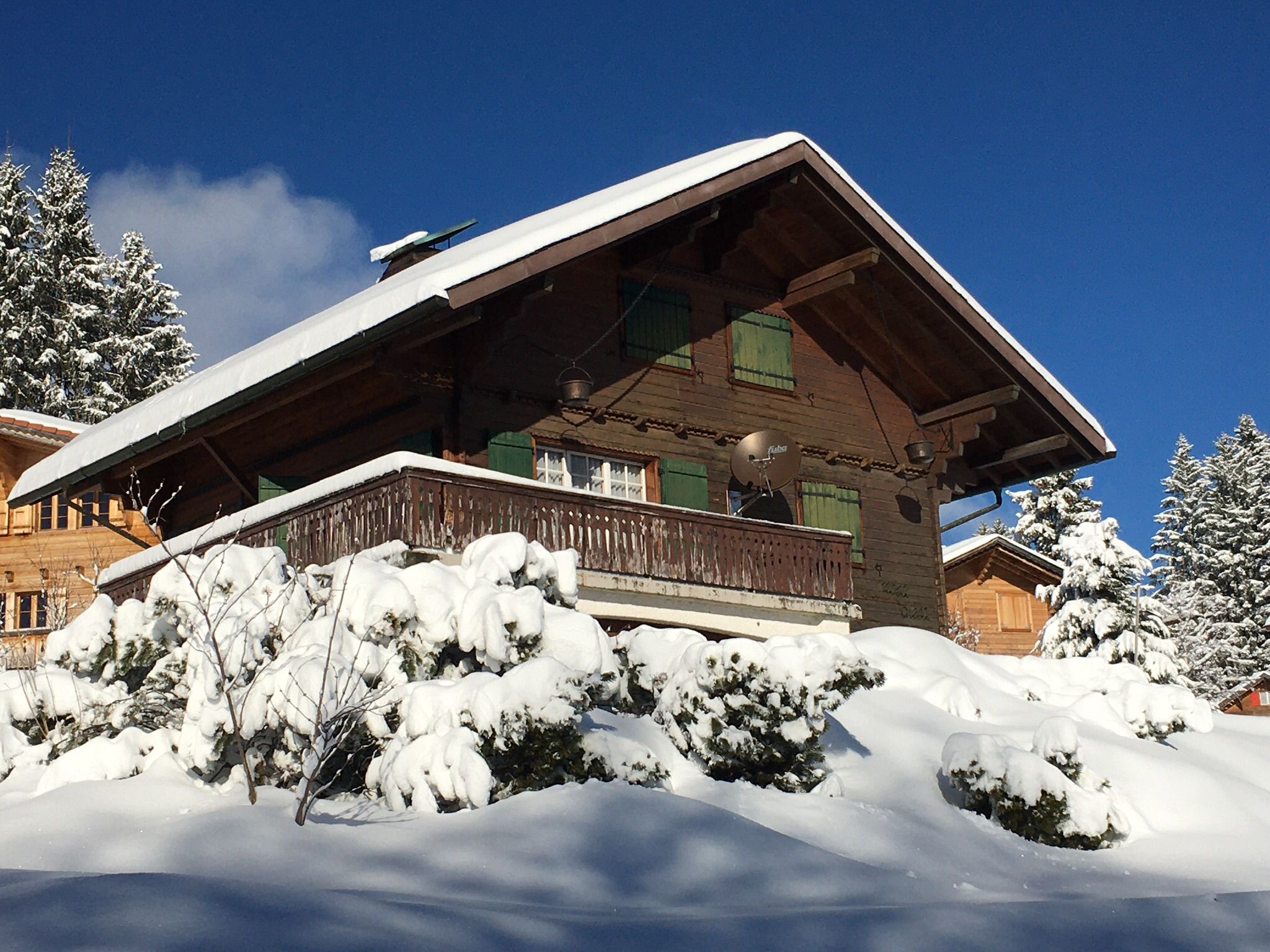 Winterliches Holzchalet mit verschneitem Satteldach