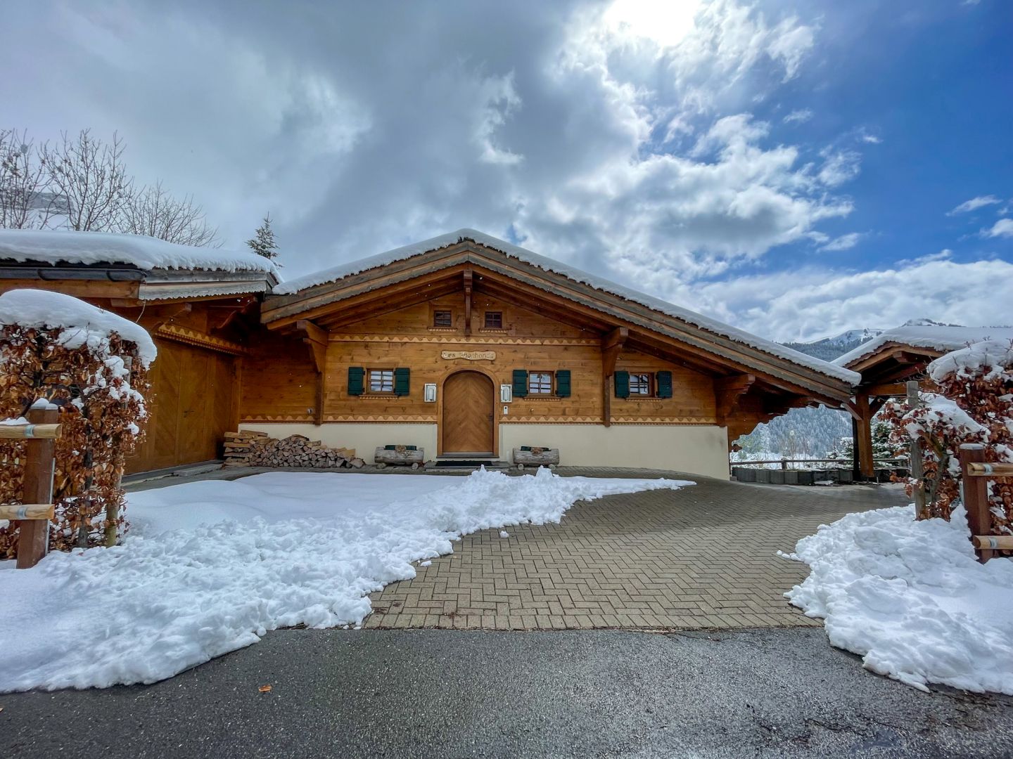 Verschneites Holzchalet mit Einfahrt