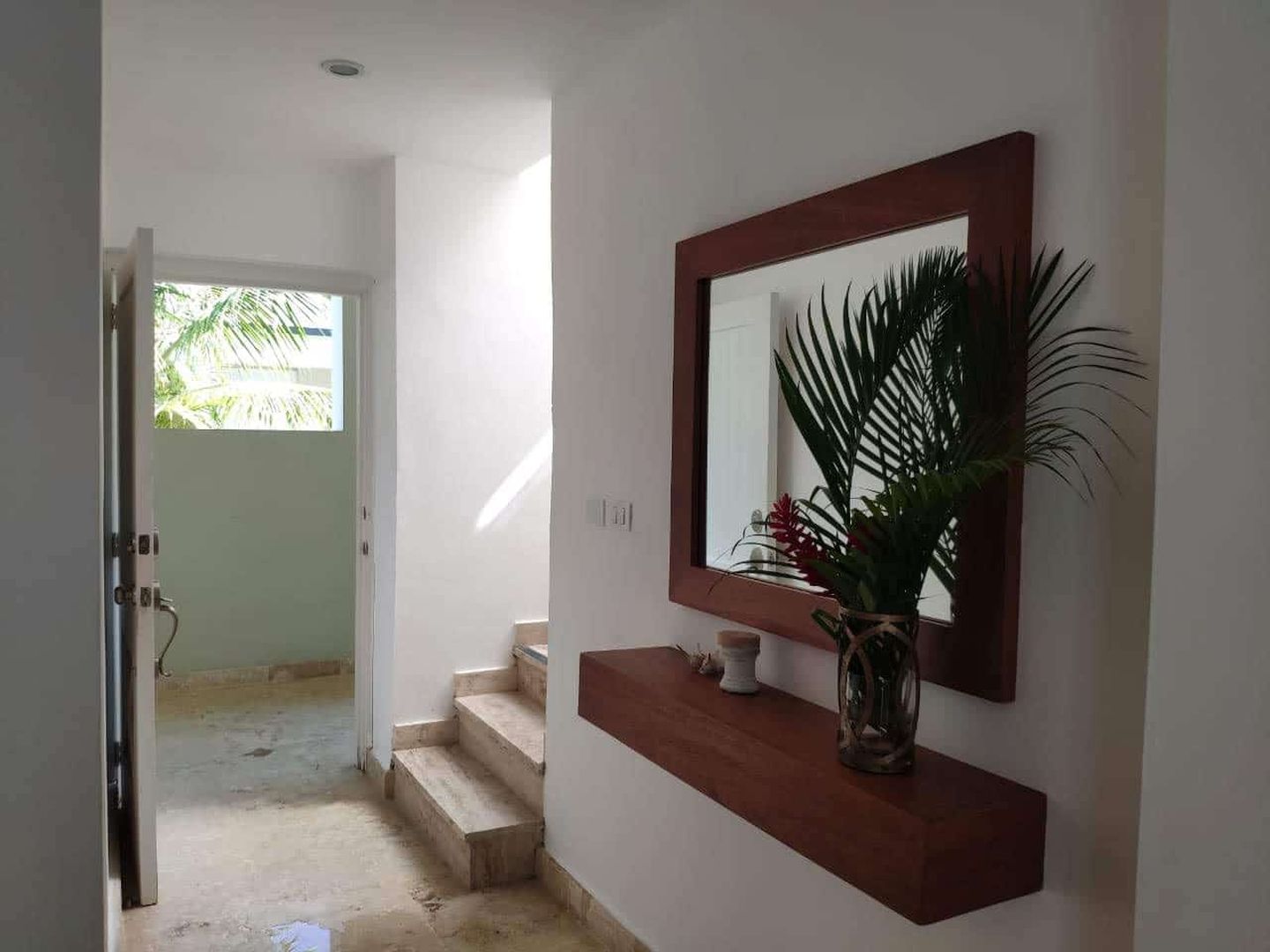 Heller Eingangsbereich mit Treppe und Wandspiegel