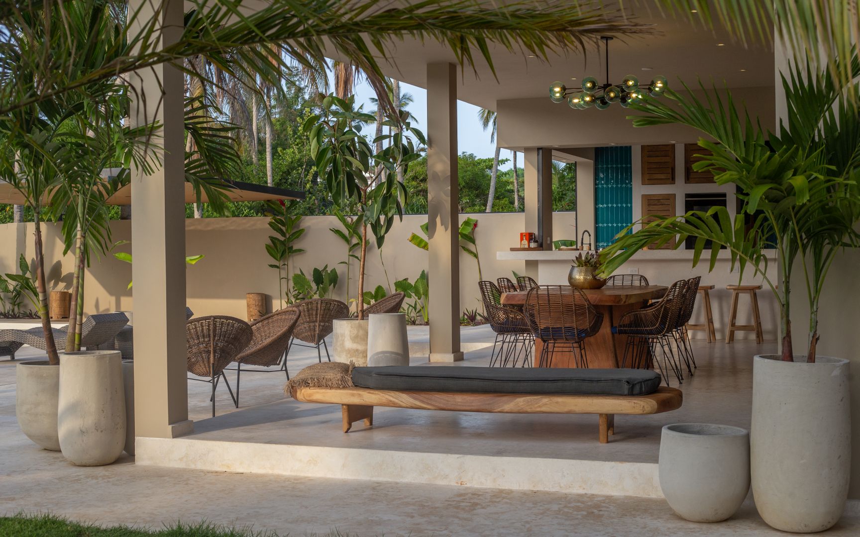Überdachte tropische Terrasse mit Ess- und Loungebereich