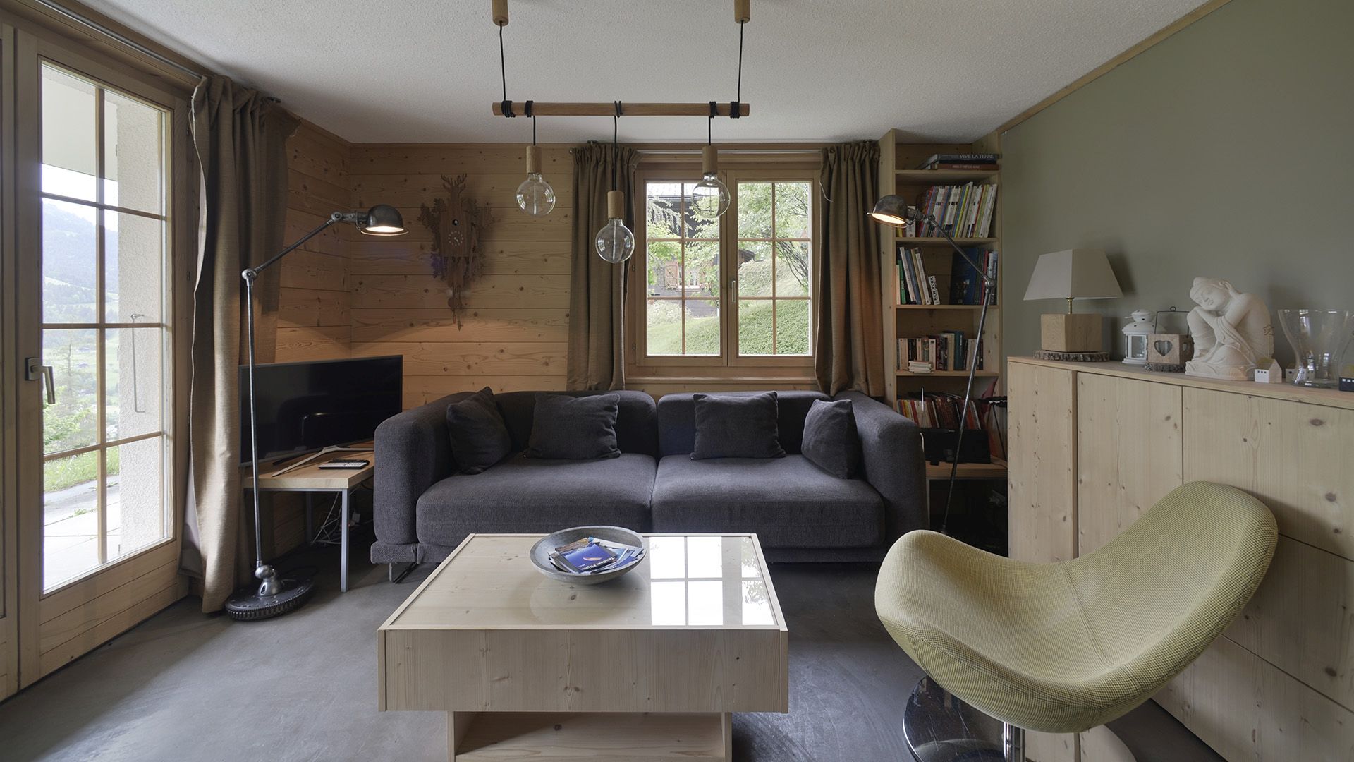 Gemütliches Wohnzimmer mit Holzverkleidung und Bergblick