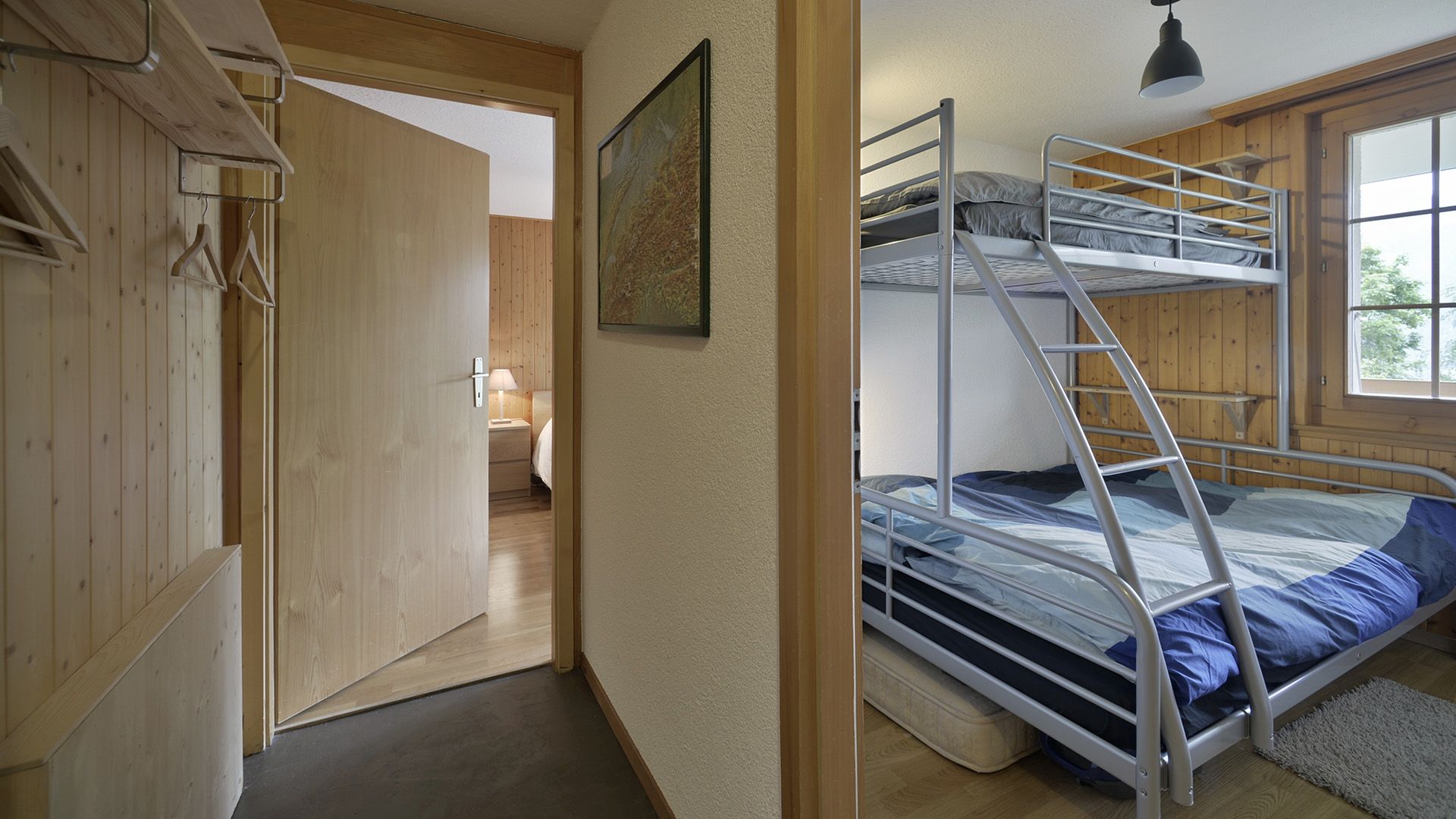 Holzvertäfeltes Schlafzimmer mit Etagenbett und angrenzendem Flur