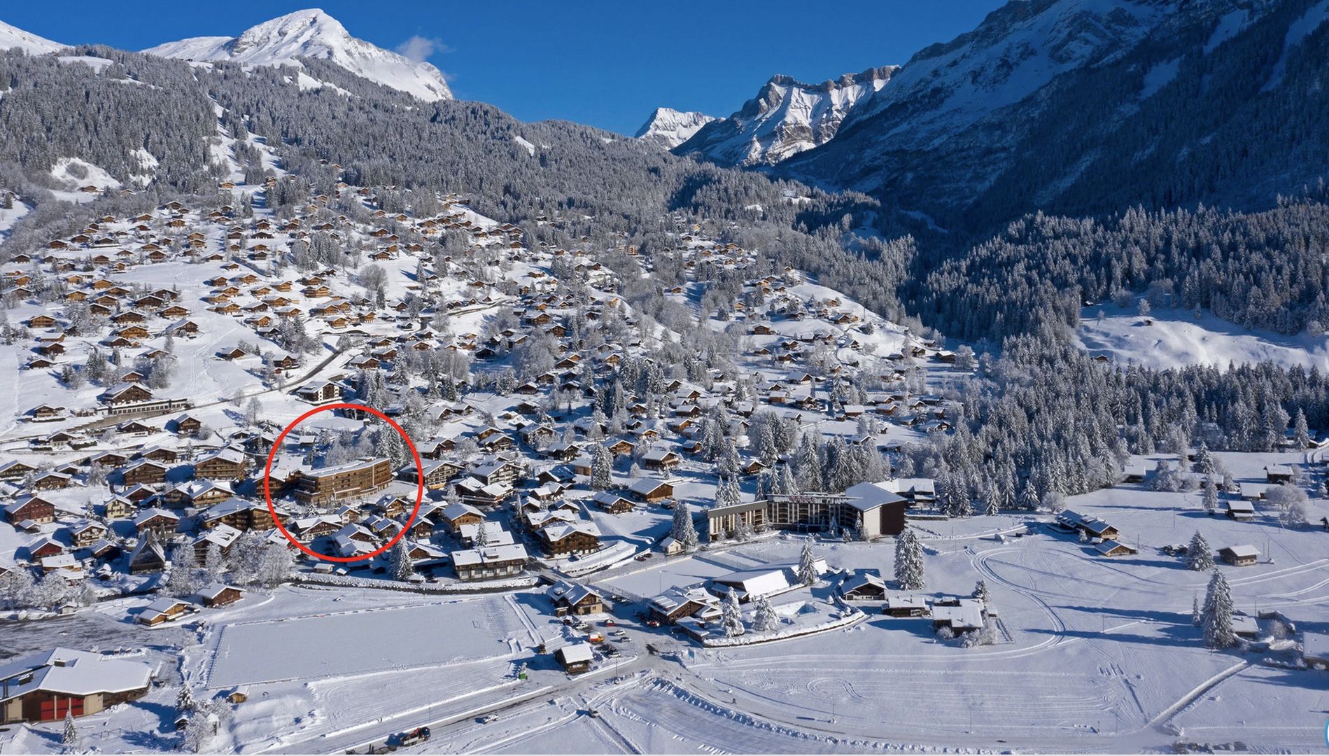 Alpenort im Schnee mit markiertem Gebäude