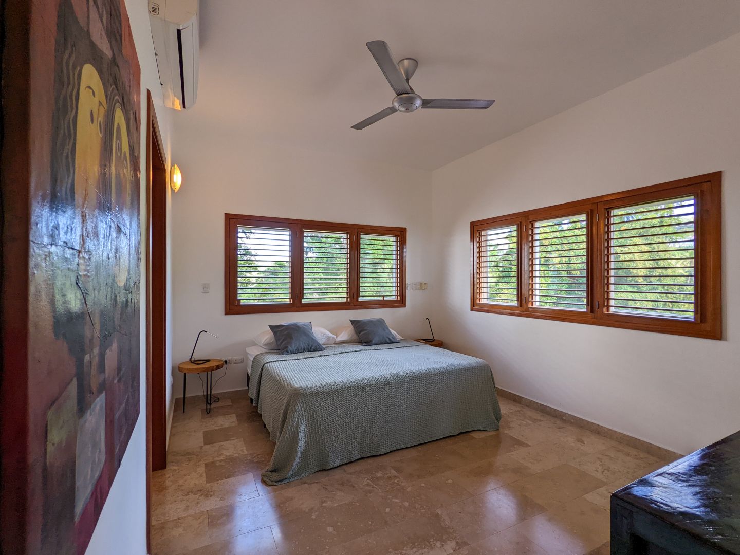 Schlafzimmer mit Holzfenstern und Natursteinboden