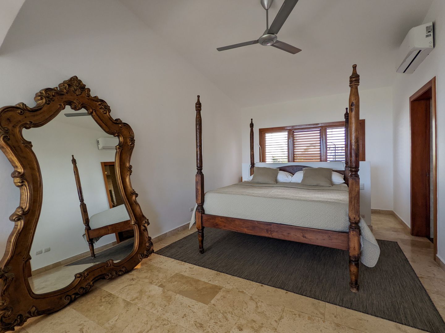 Schlafzimmer mit Holz-Mobiliar und großem Spiegel