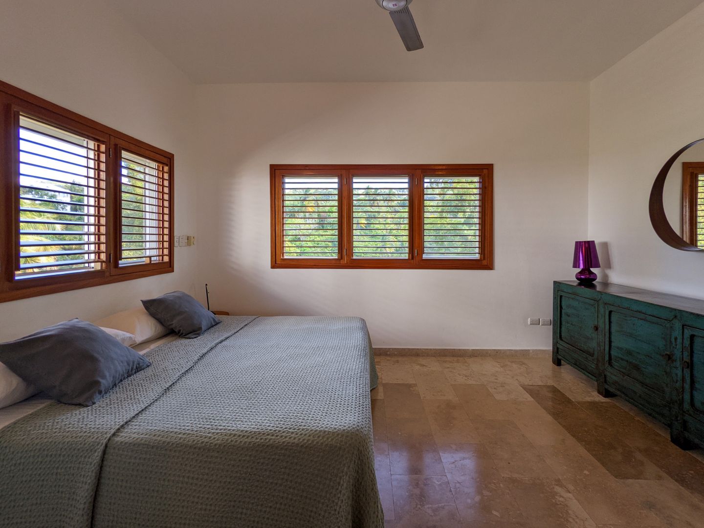 Schlafzimmer mit Holzfenstern und Bett