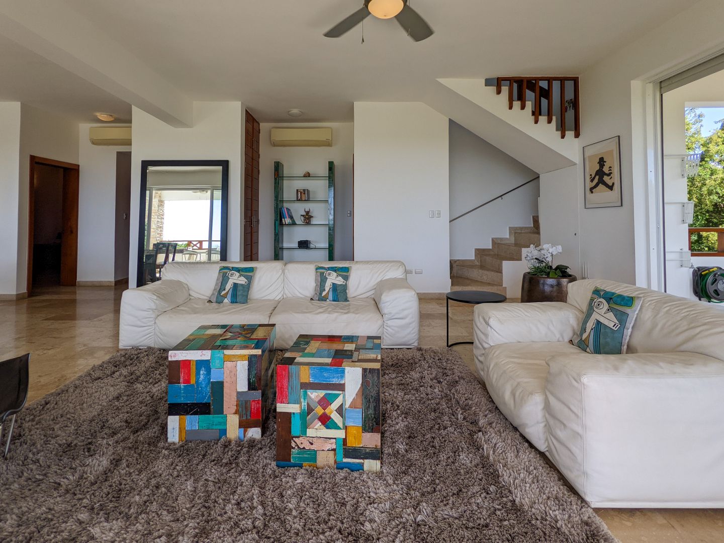 Helles Wohnzimmer mit Sitzgruppe und Treppe