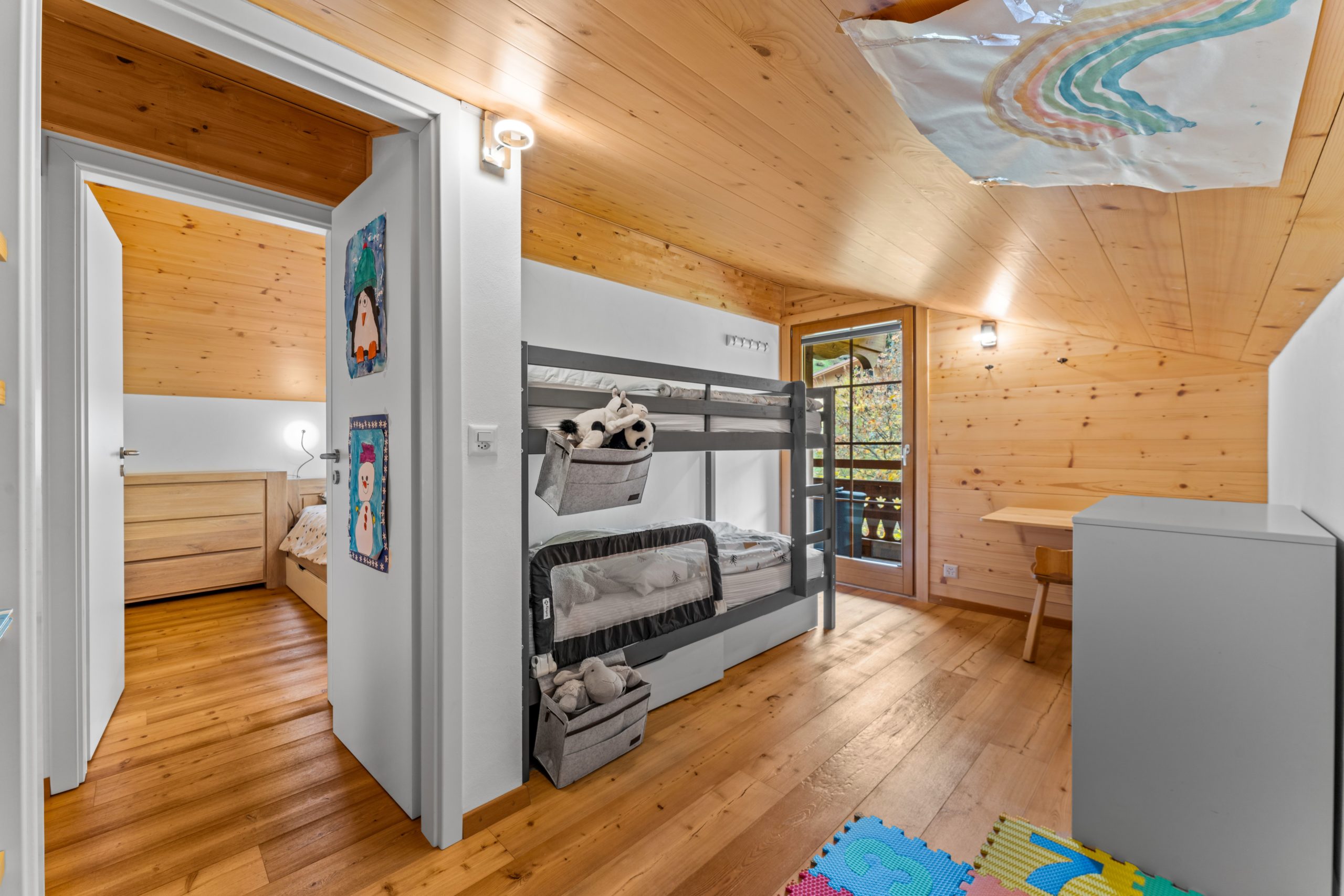 Kinderzimmer mit Hochbett und Holzverkleidung