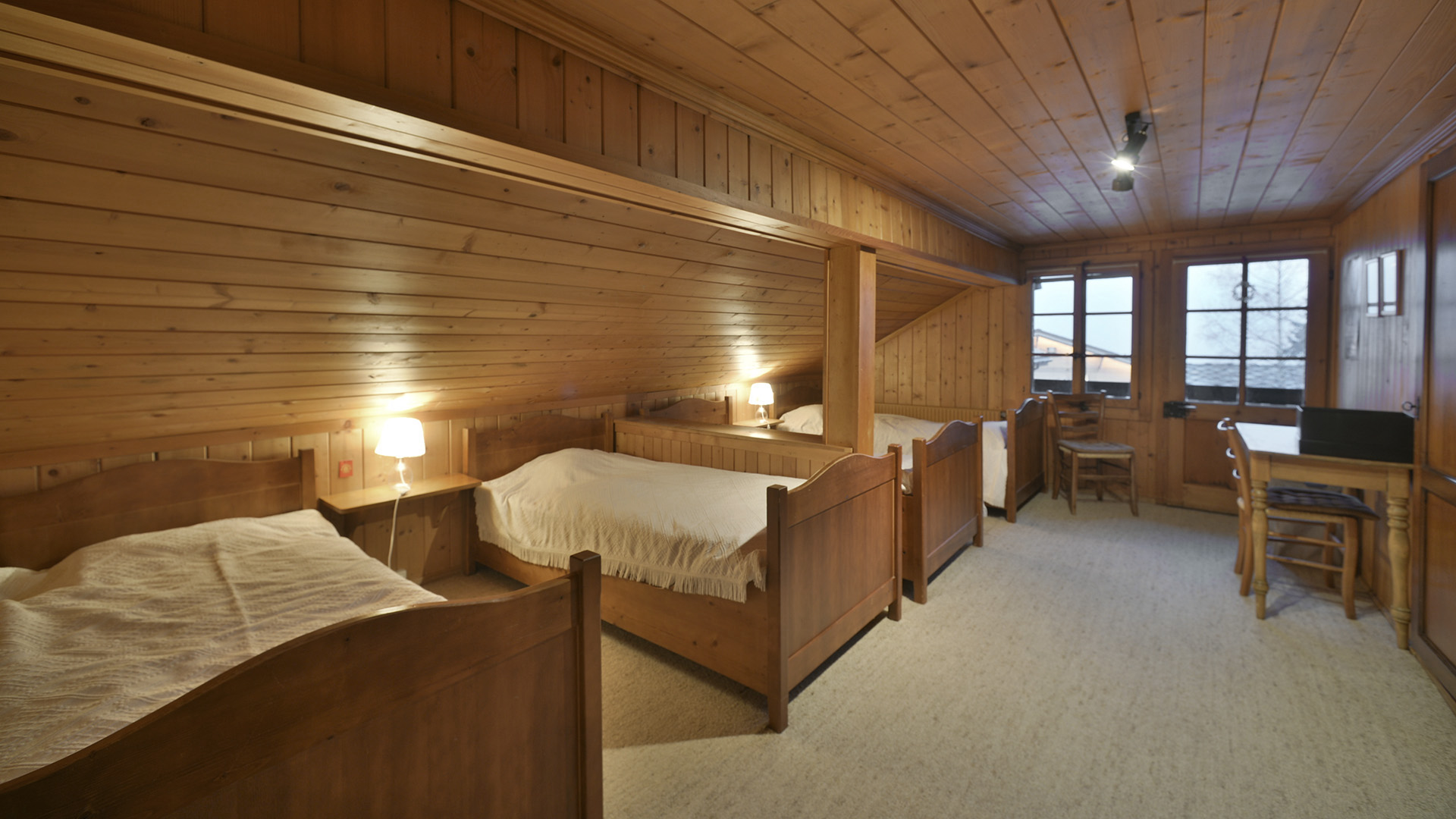 Gemütliches Holzschlafzimmer mit mehreren Betten