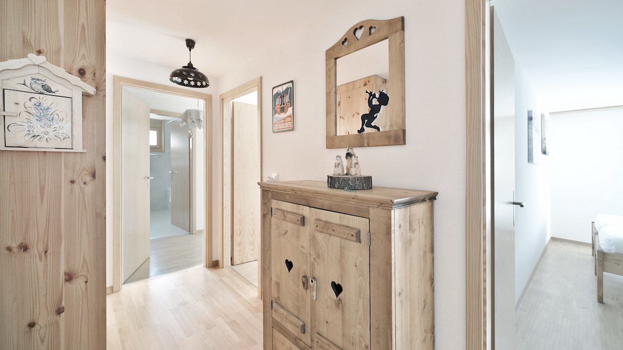 Heller Flur mit Holzdekor und Blick ins Schlafzimmer