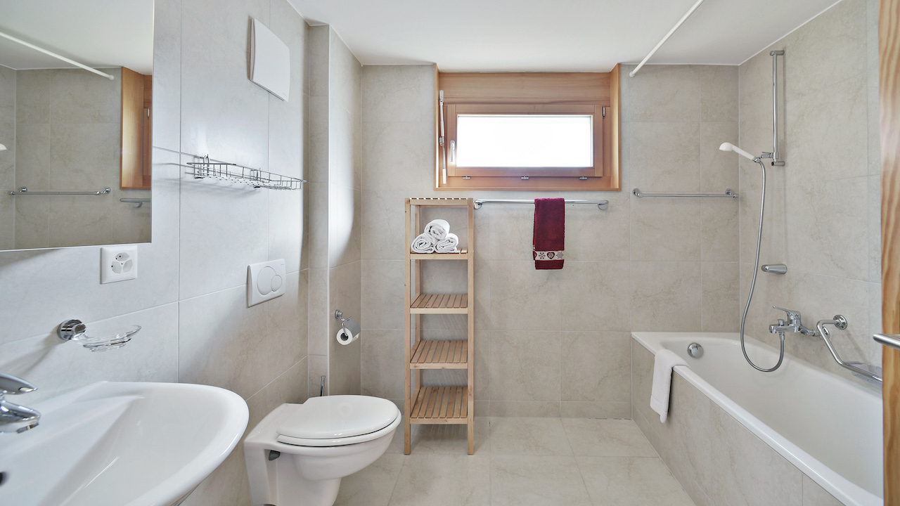 Helles Badezimmer mit Badewanne und Fenster