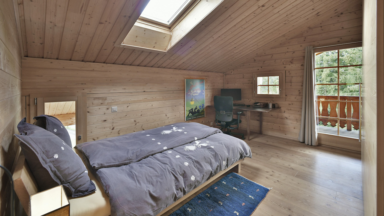 Gemütliches Holzschlafzimmer mit Dachfenster